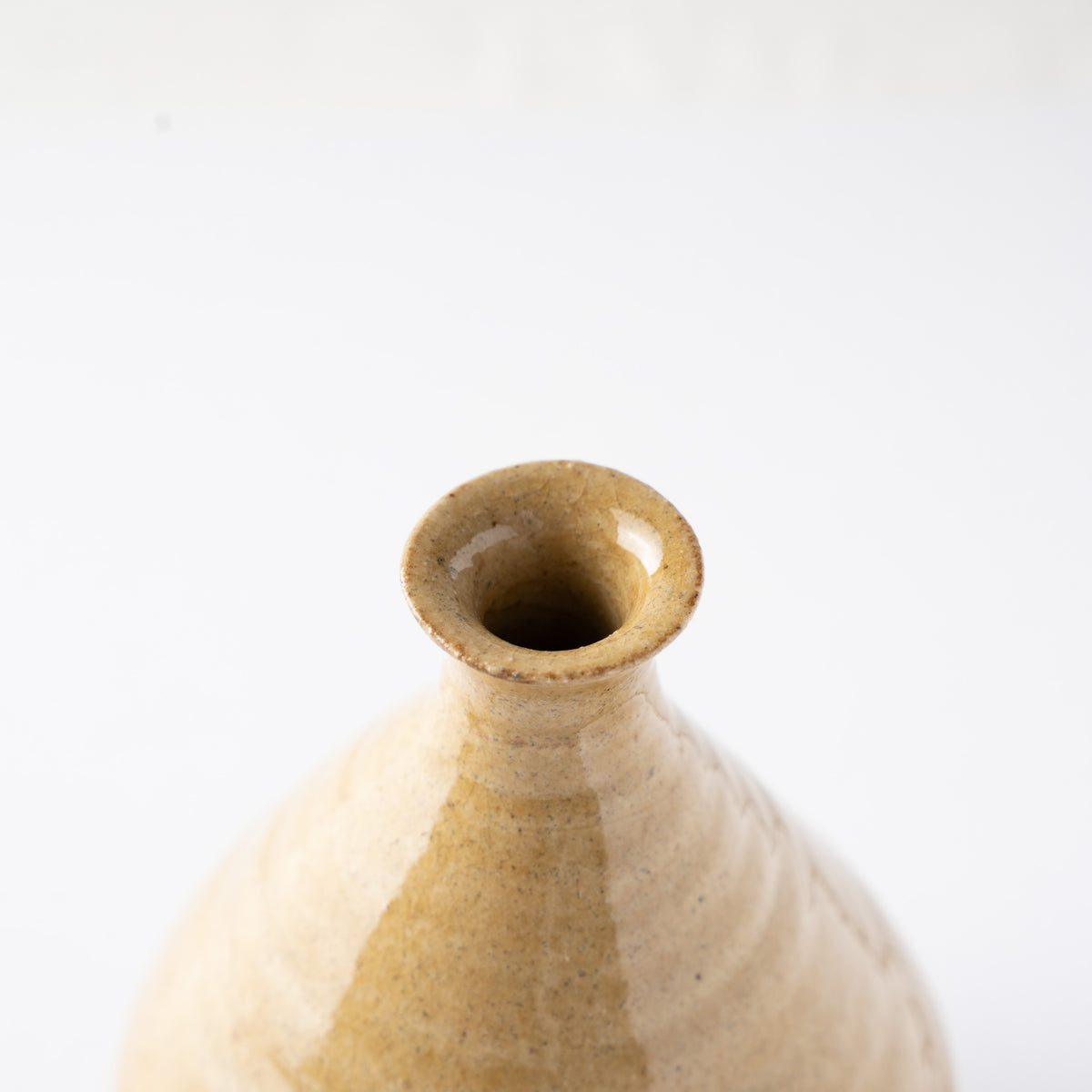Close-up view looking directly into the open mouth rim of the yellow glaze TOKKURI sake flask by Noriyuki Furutani.