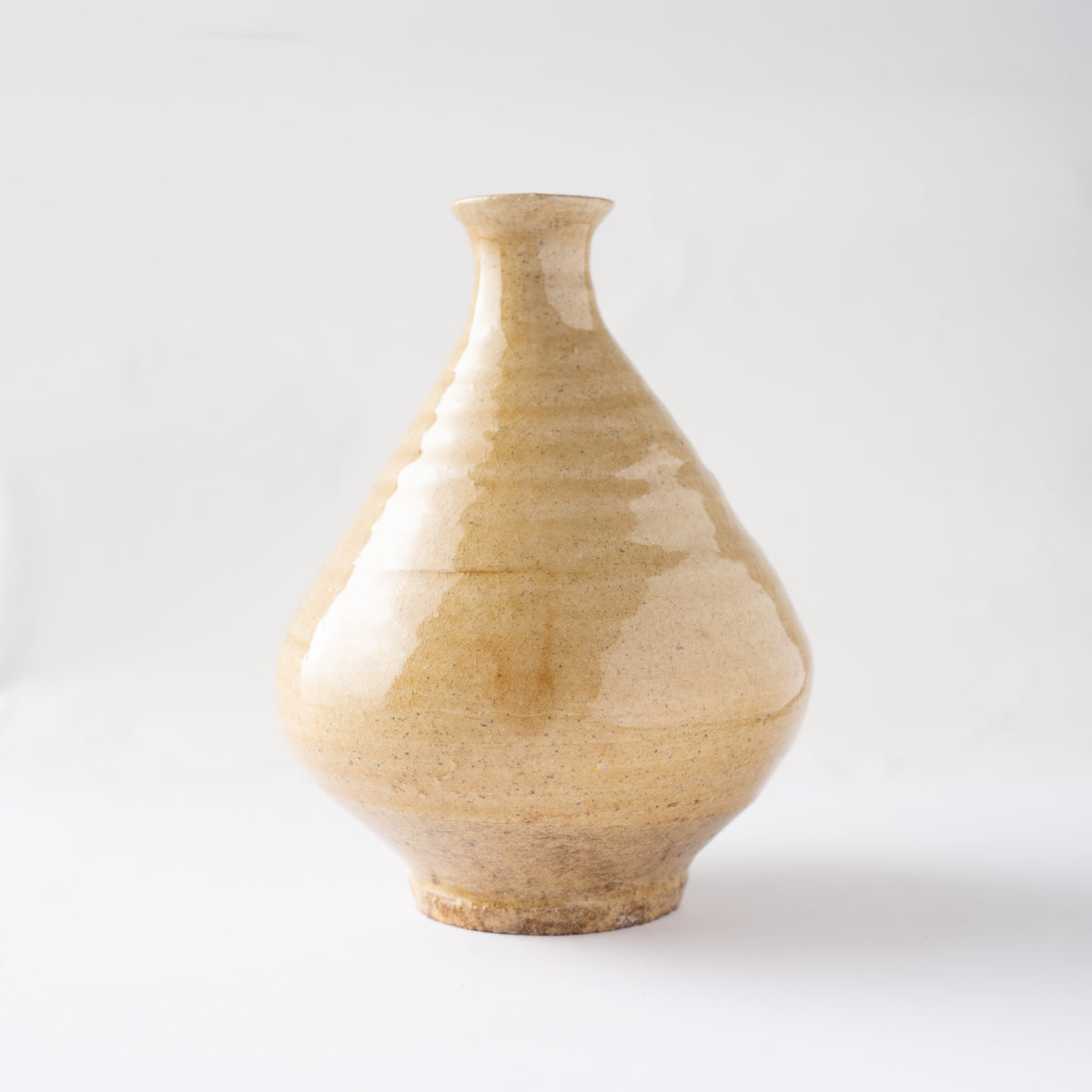 Turned side view of the yellow glaze TOKKURI by Noriyuki Furutani, highlighting the subtle wheel-thrown ridges catching light.