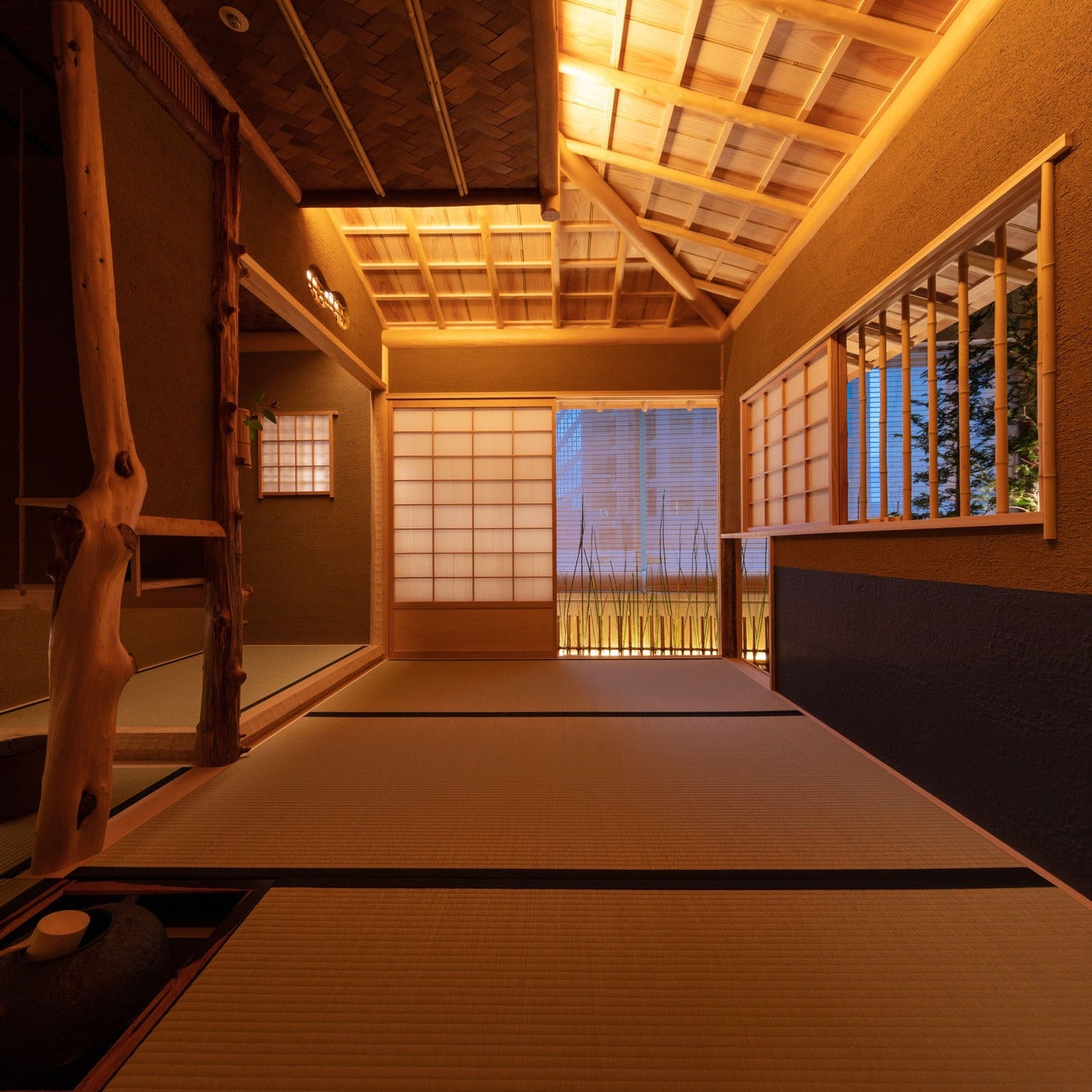 The chashitsu opens through paper screens to a hint of the city beyond, a hearth and natural post anchoring the tatami room.