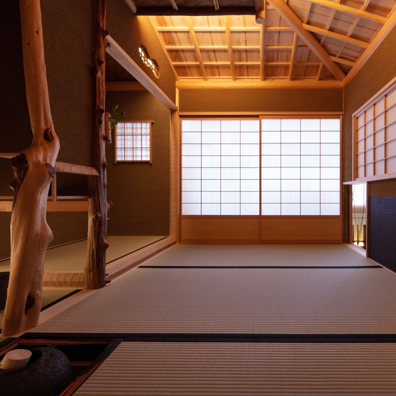 Interior of the chashitsu with a sunken hearth set into the tatami and a natural central post.