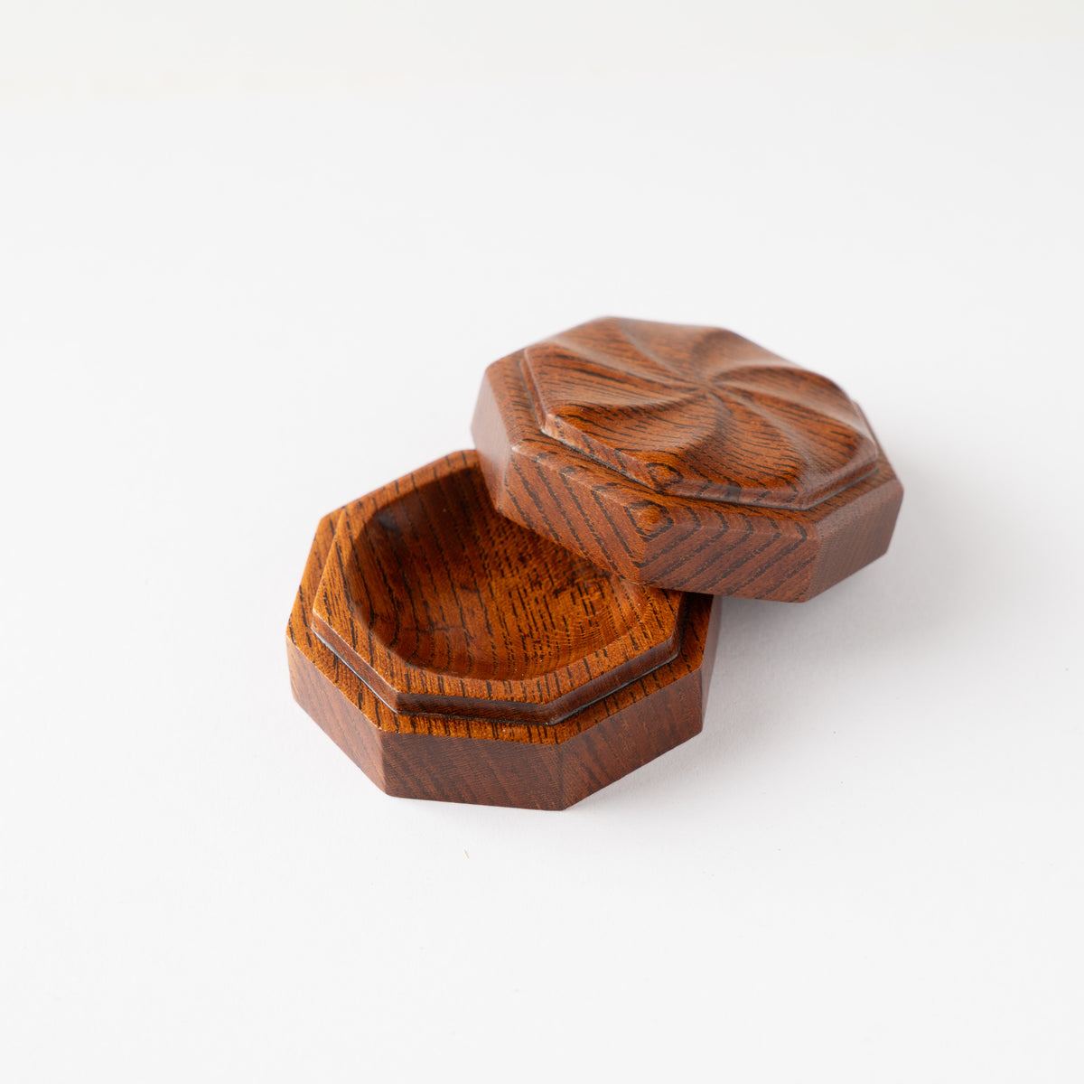 Alternate turned perspective of Osamu Oyama's octagonal wood KOGO incense container open, showing the amber-toned fuki-urushi lacquer finish.