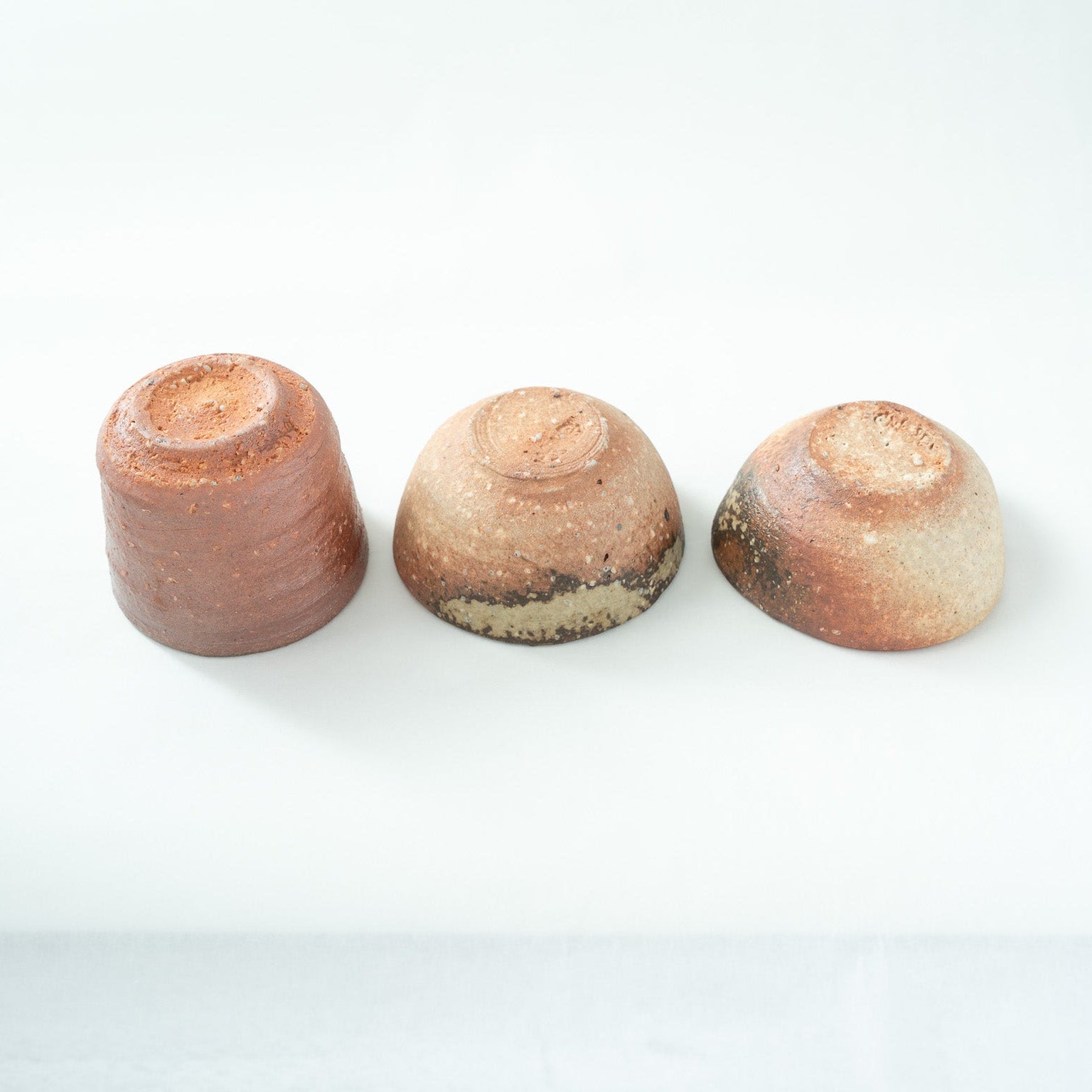 Detailed view of the upside-down sake cups, highlighting the natural color transitions near the base and the precise trimming of the feet.