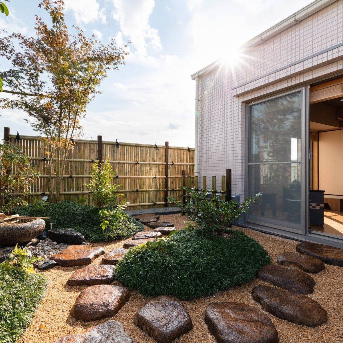 Tatami room opening onto a rooftop tea garden with a maple, stepping stones and a bamboo fence above the Tokyo skyline, contemporary Japanese architecture.