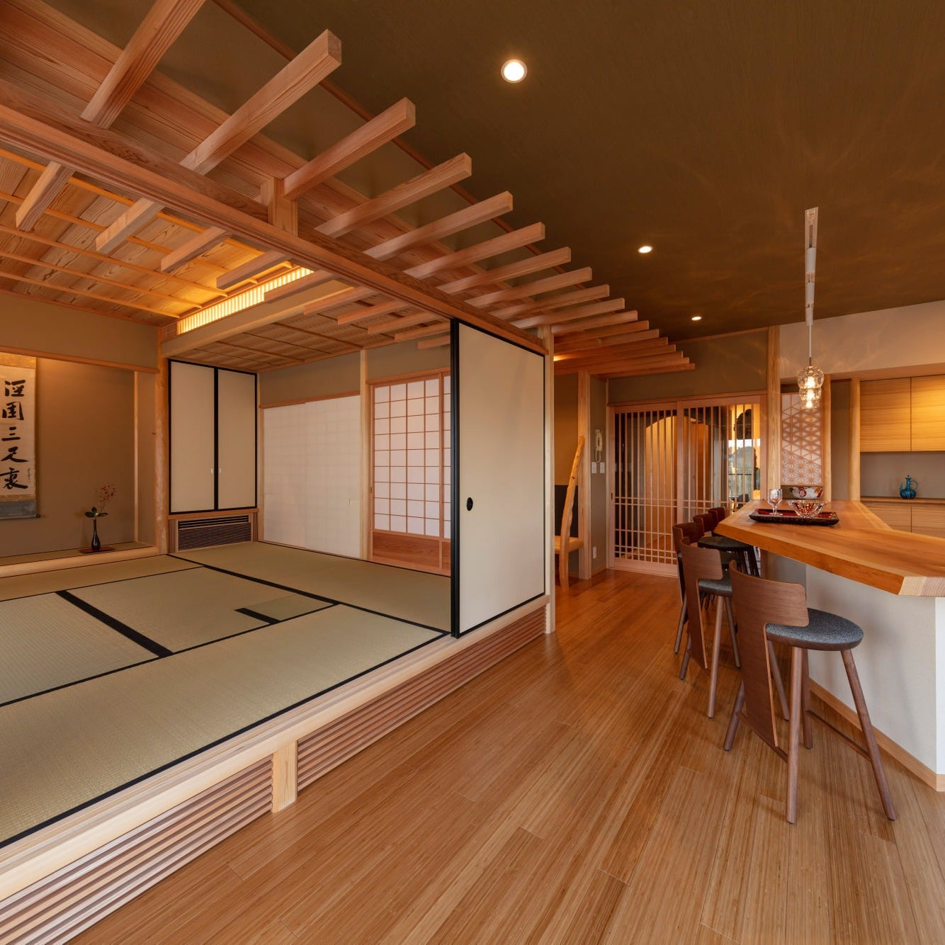 Eight-mat tatami hall with a tokonoma and a descending woven-bamboo and rafter ceiling, seen from the salon by day.