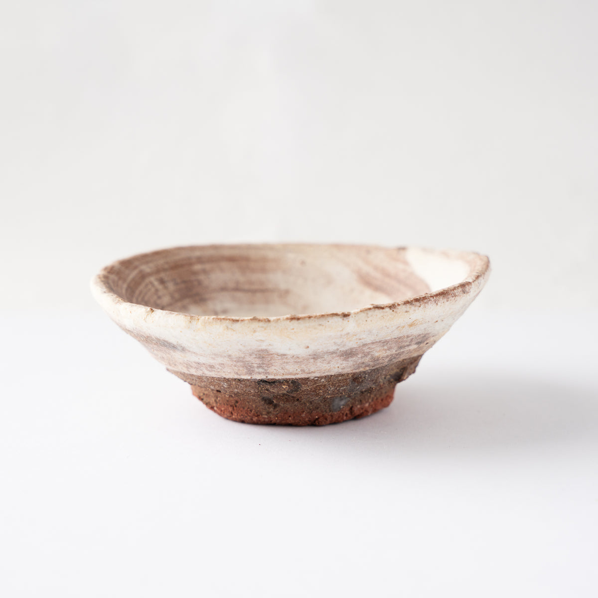 Full side view of Ryusuke Asai's shallow ceramic GUINOMI, showing the gentle flare of the rim and iron wash brush marks.