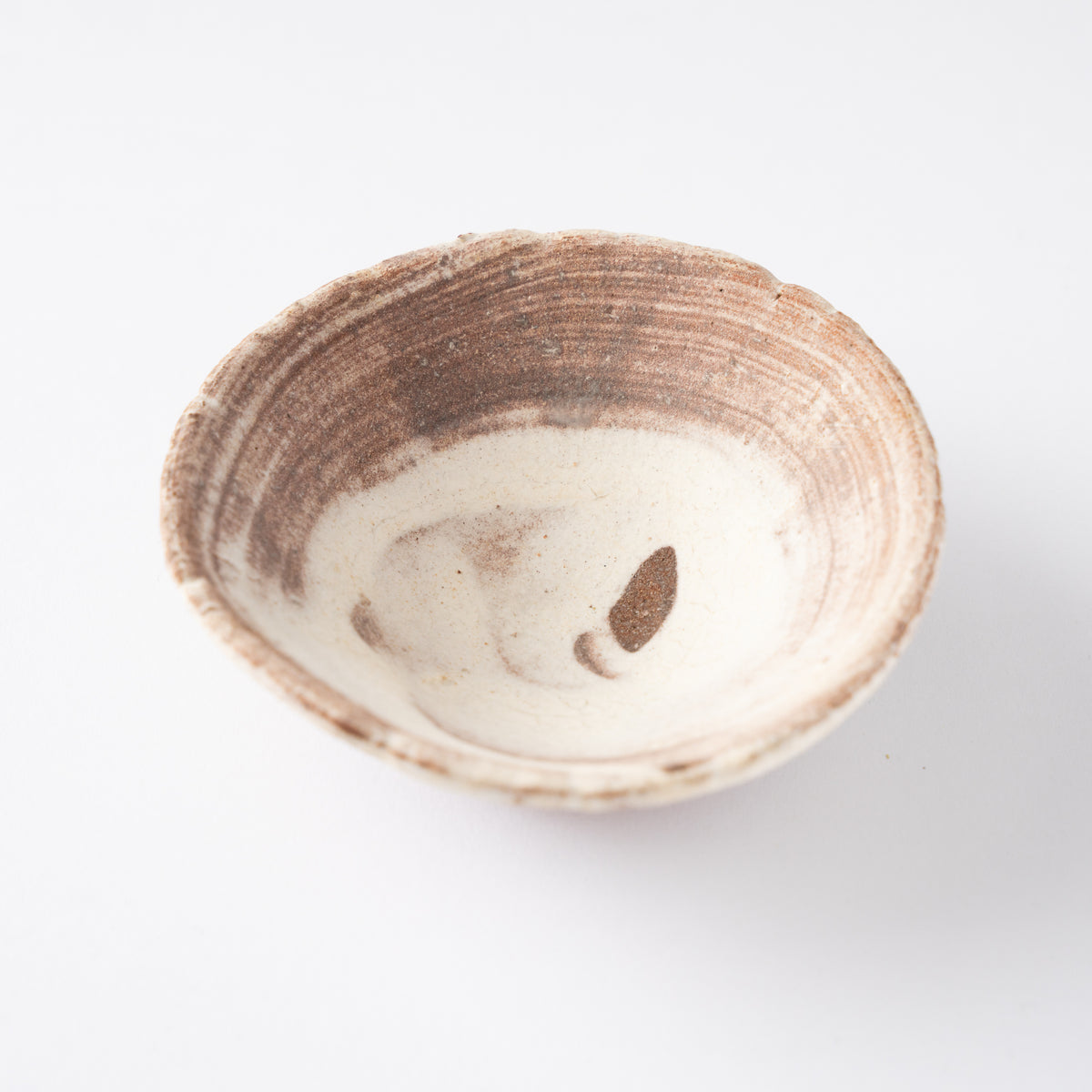 High-angle interior view of Ryusuke Asai's shallow GUINOMI sake cup, showing swirling iron brushstrokes and a single central iron mark.