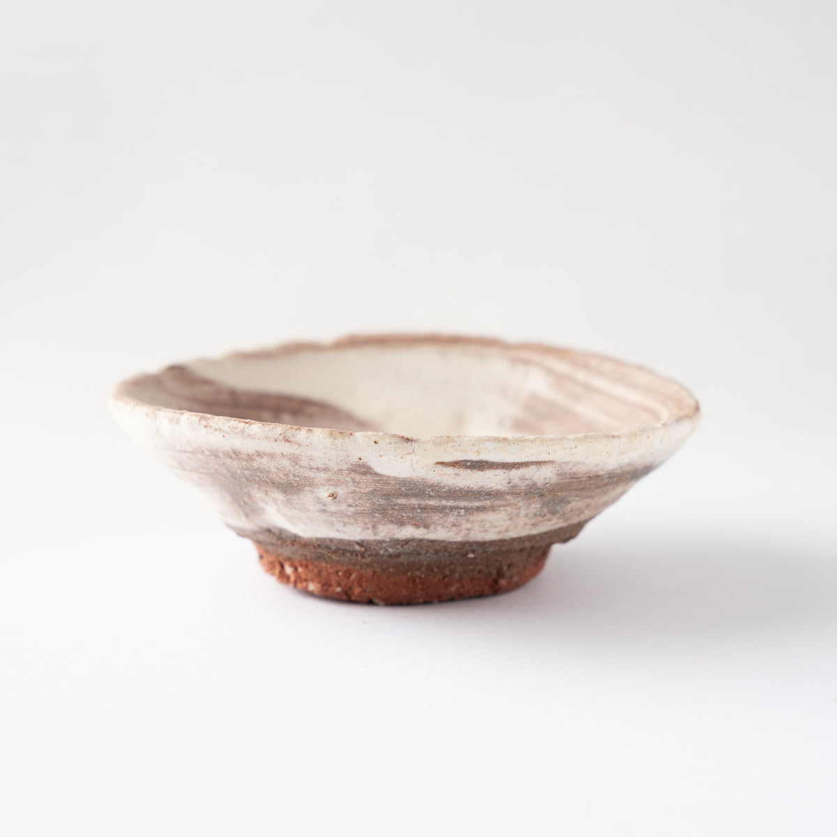 Turned side profile view of the shallow GUINOMI sake cup by Ryusuke Asai against a plain studio background.