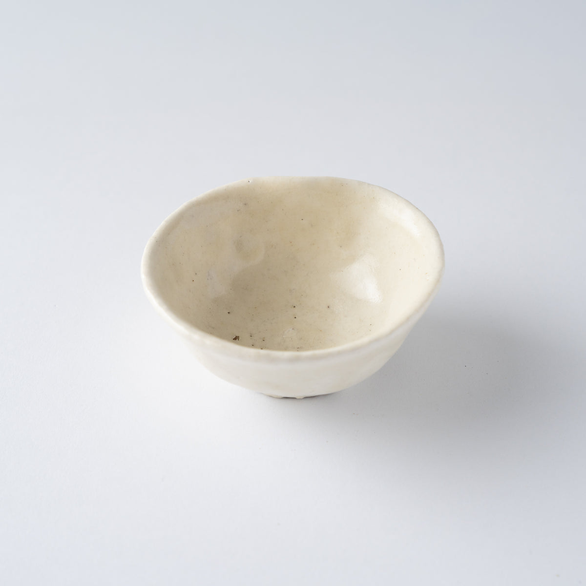 Three-quarter top view of the open Kohiki SAKAZUKI sake cup by Seiya Toyoba, showing the soft eggshell glaze sheen.