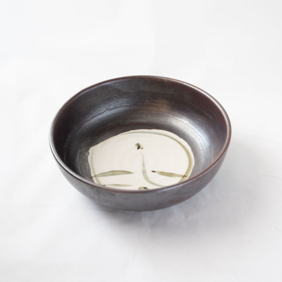 Alternated top view of the iron-glazed Shigaraki bowl, illustrating the natural movement of the dark glaze and the spatial balance of the central white motif.