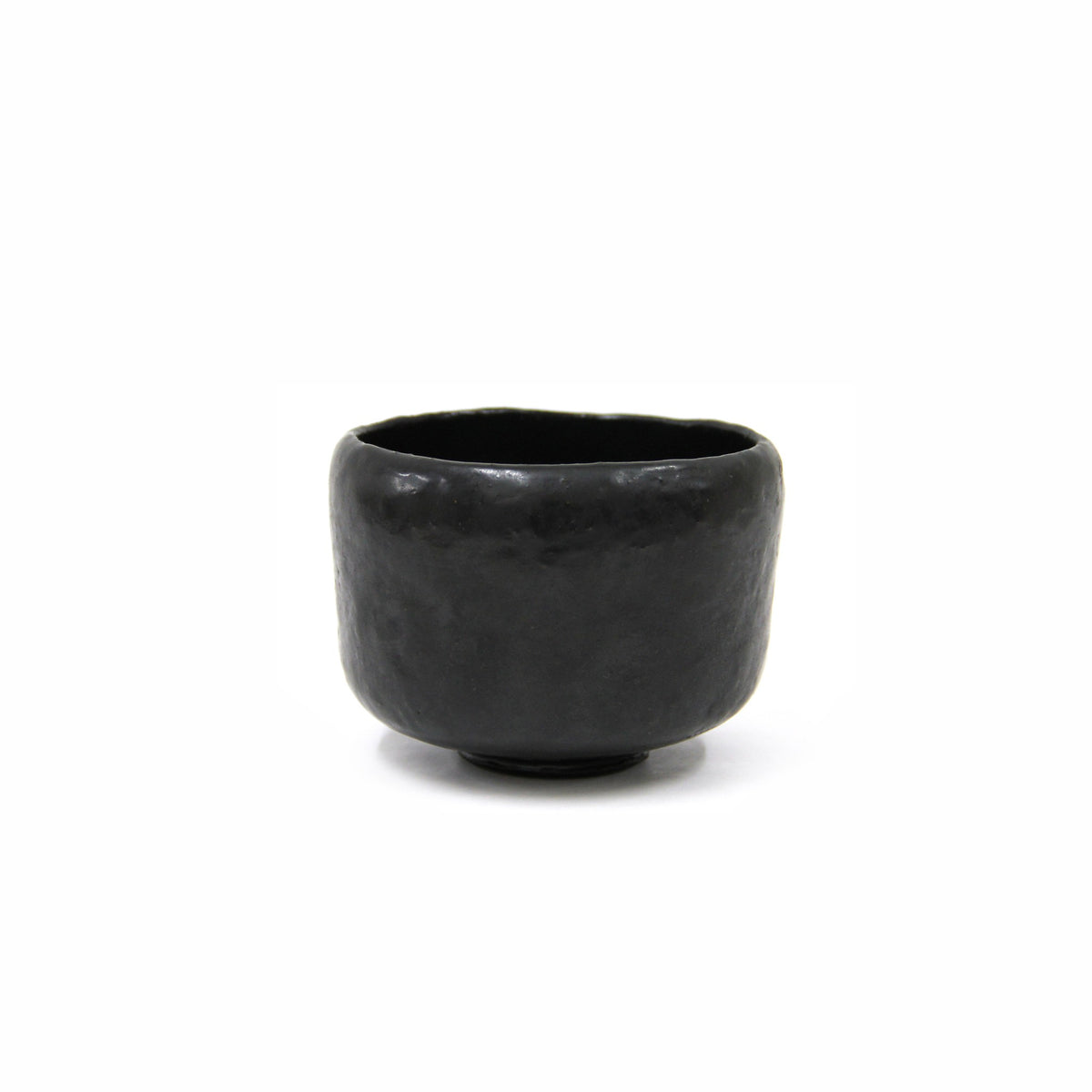 Front view of the black cylindrical tea bowl on a white ground, the semi-matte glaze showing a faint highlight on the shoulder.