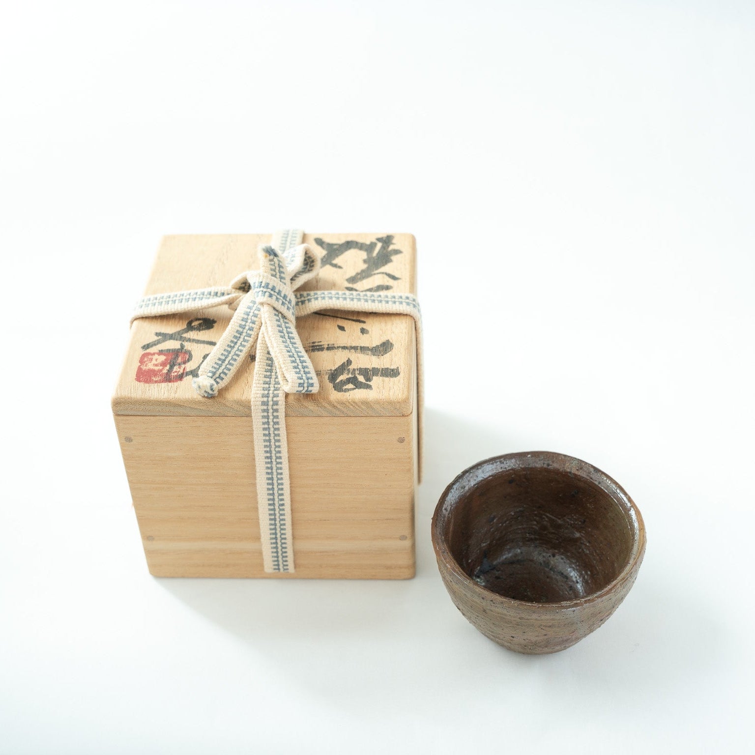 Shiro Tsujimura's rustic ceramic GUINOMI presented beside its original signed wooden box (tomobako) tied with a traditional ribbon.