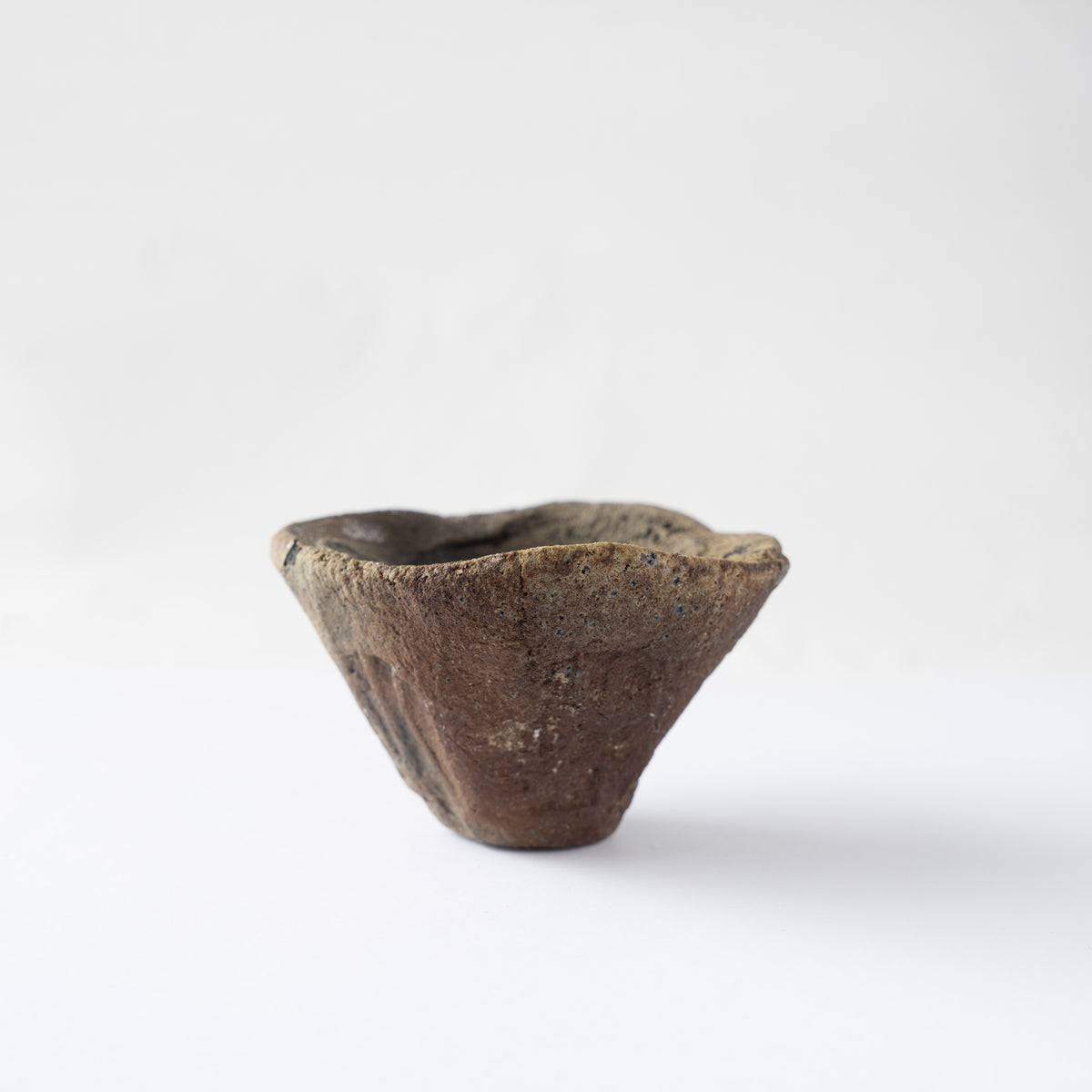 Turned profile of the GUINOMI cup by Tamotsu Funakoshi, showcasing hand-carved vertical grooves on the scorched ceramic body.