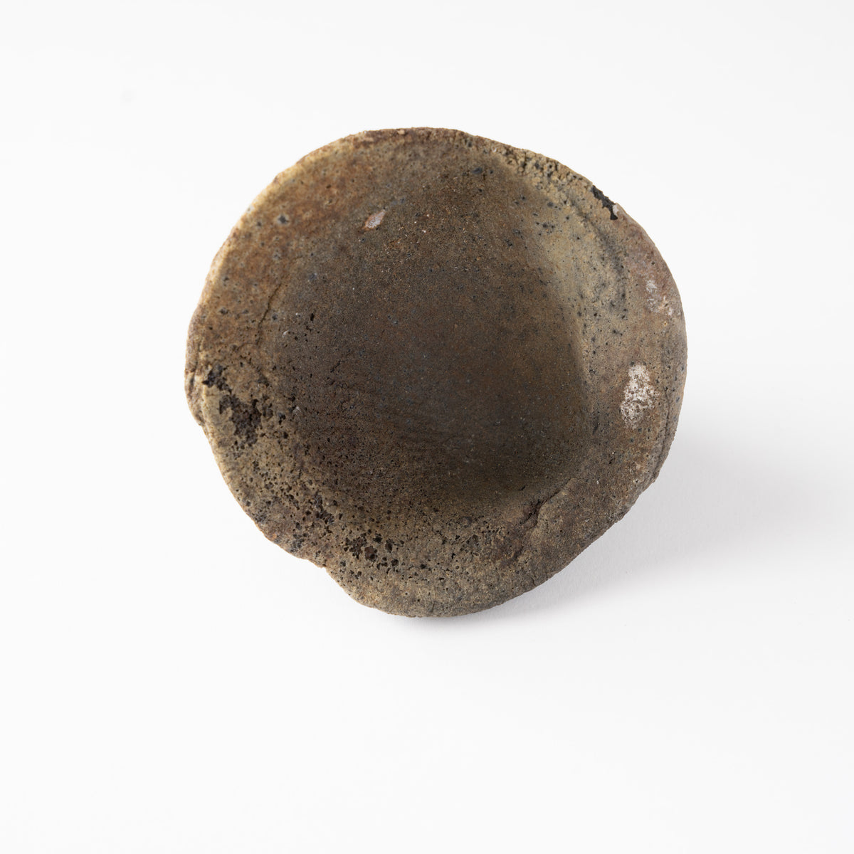 Top-down view looking into the interior of Tamotsu Funakoshi’s ceramic GUINOMI sake cup, displaying its coarse clay texture.