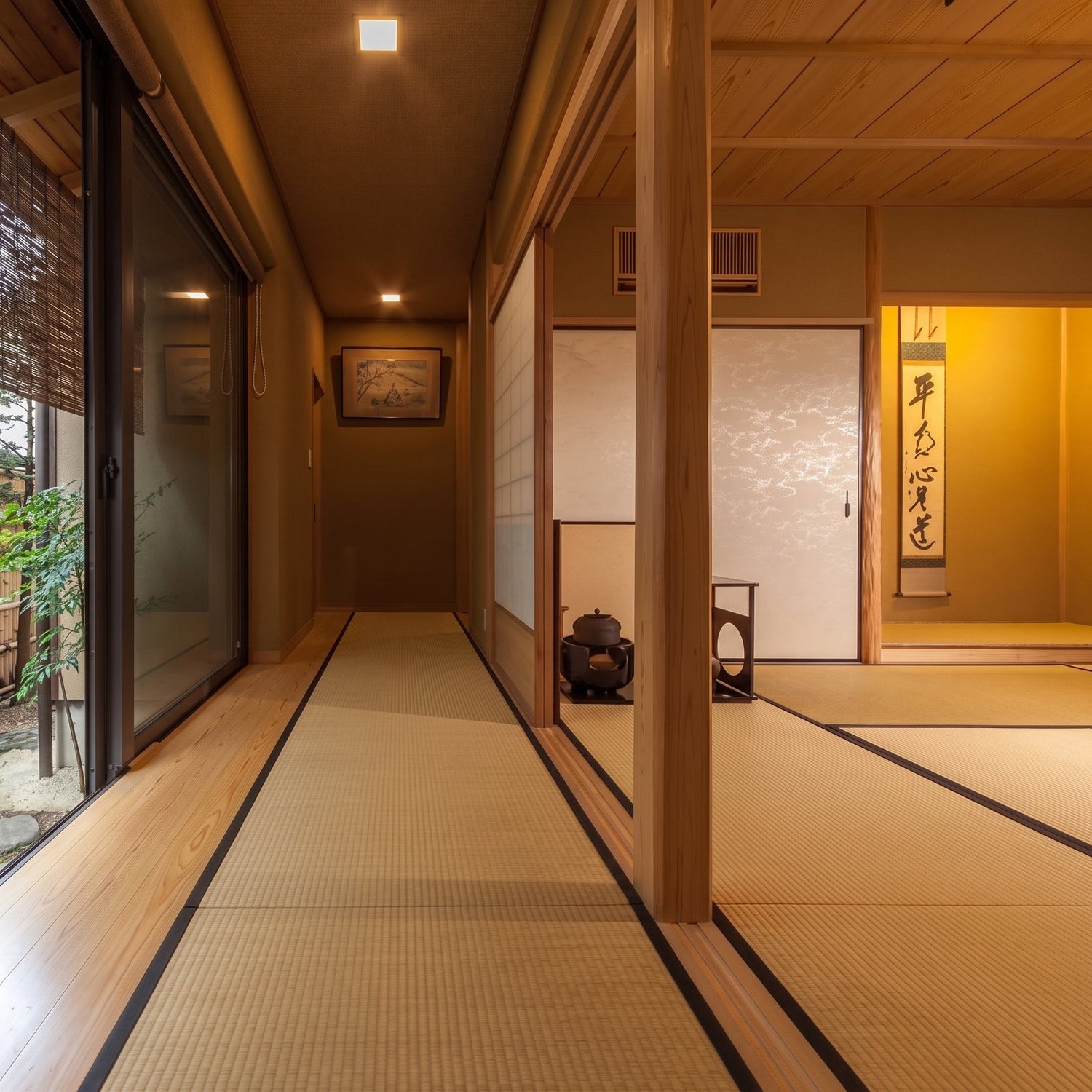 A serene view down a traditional tatami-matted corridor towards a peaceful inner garden.