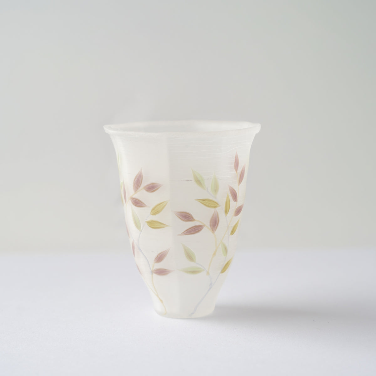 Full front profile of Toru Sato’s white octagonal glass GUINOMI, showing the elegant flare of its faceted rim.
