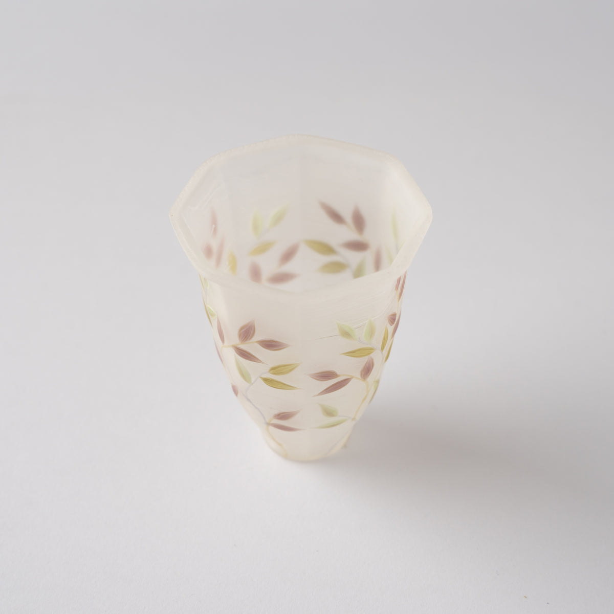 High-angle view looking down into the frosted white octagonal glass GUINOMI by Toru Sato, showing the interior leaf patterns.