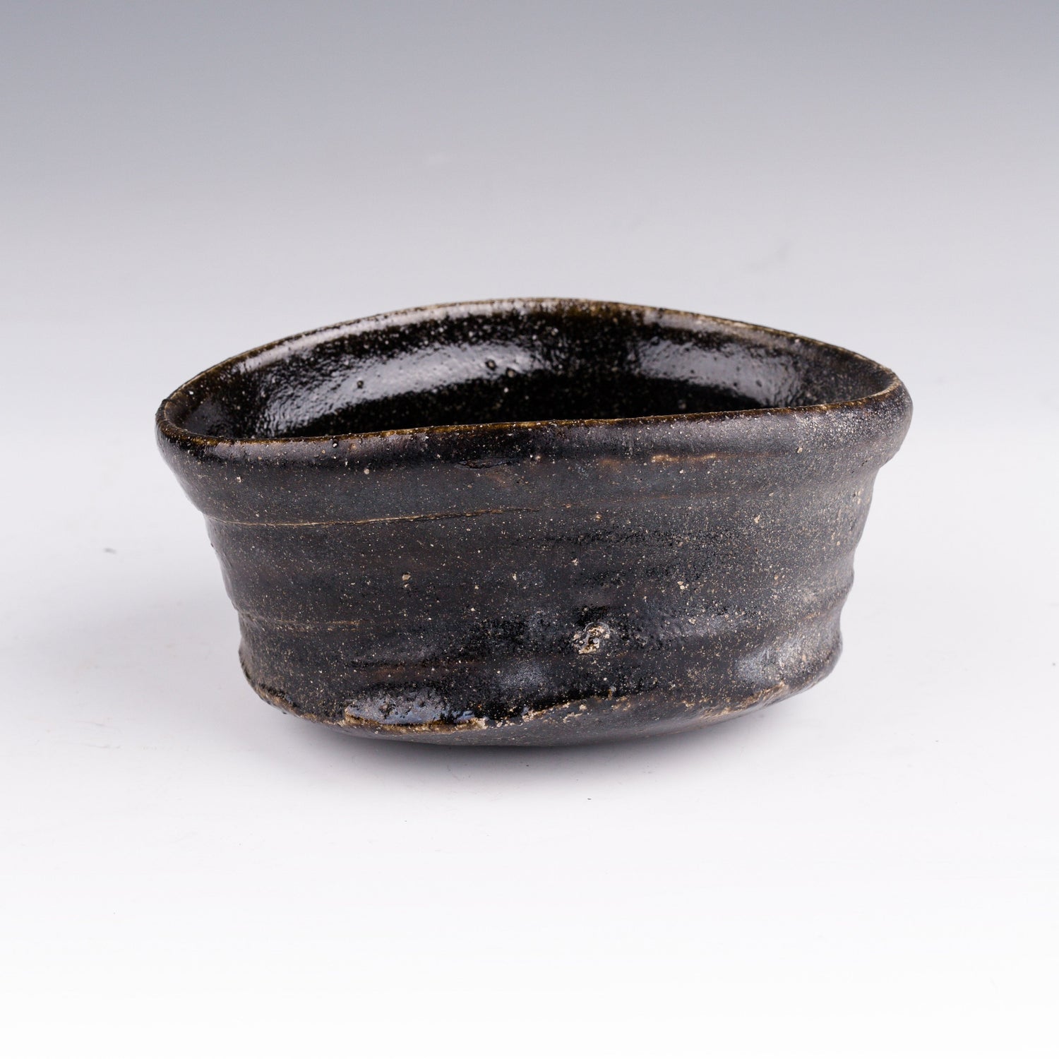 Side view of an Oribe black chawan tea bowl by Tsujimura Kai Japanese ceramic