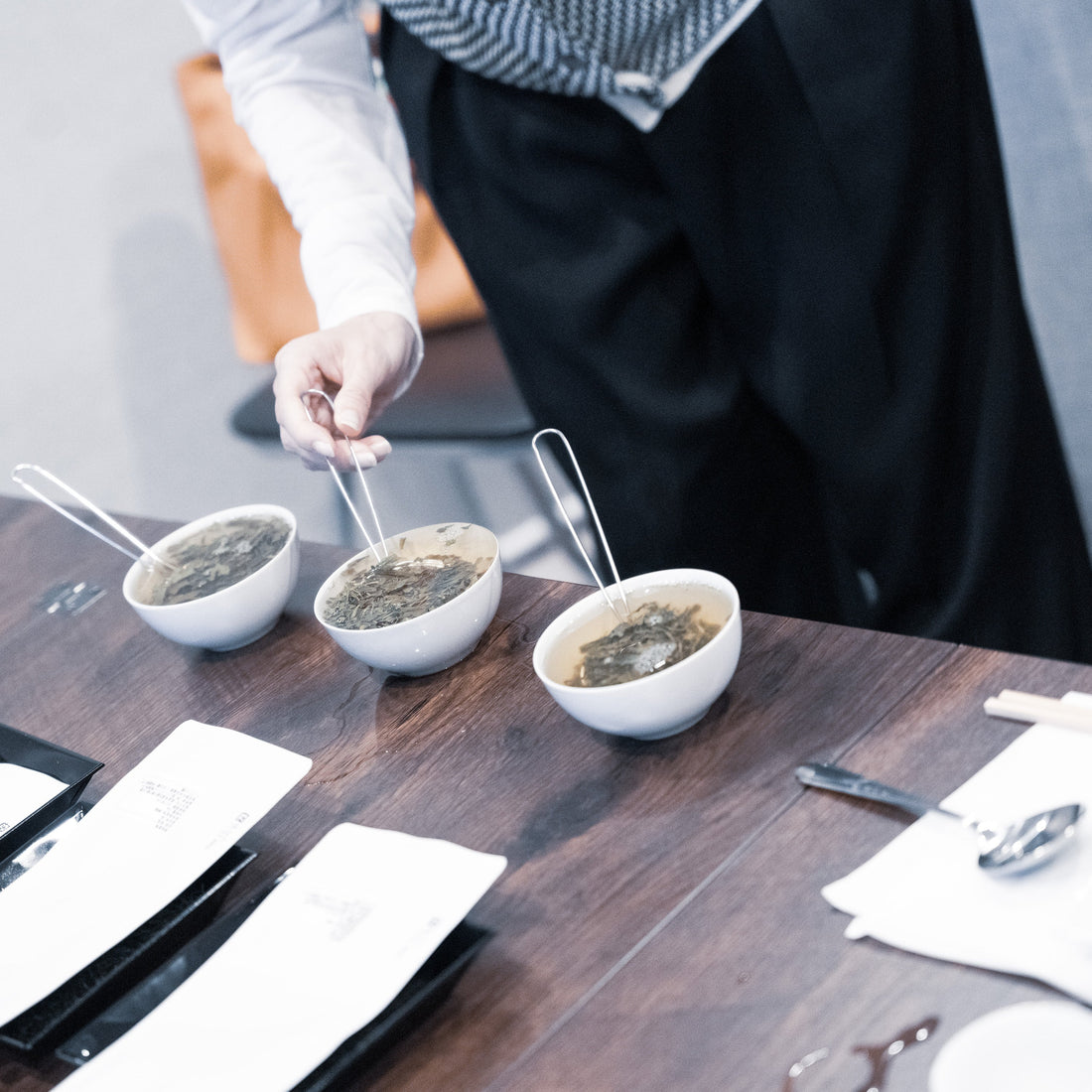 A person carefully pouring hot water to prepare a flight of Japanese teas during a hands-on tasting and learning experience at Roppongi Tea Factory.