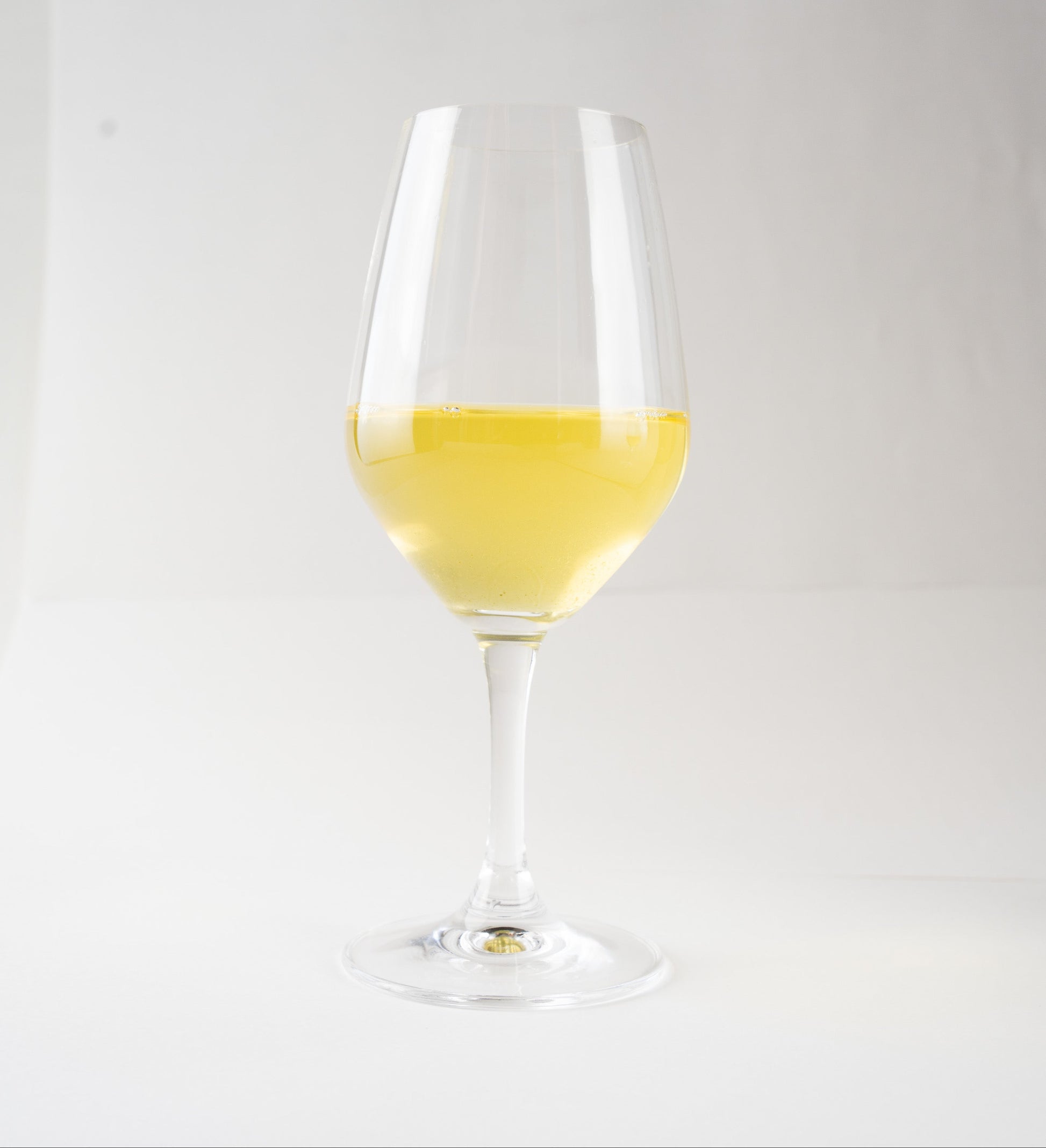 Luminous pale-green cold-brewed Sencha 'Nonokaze' served in a delicate wine glass against a minimal white background.