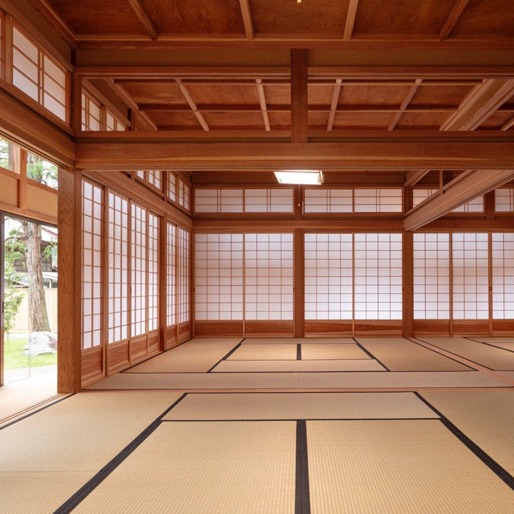 広々とした和室。整えられた畳と木組み、障子。その先に庭が見える。