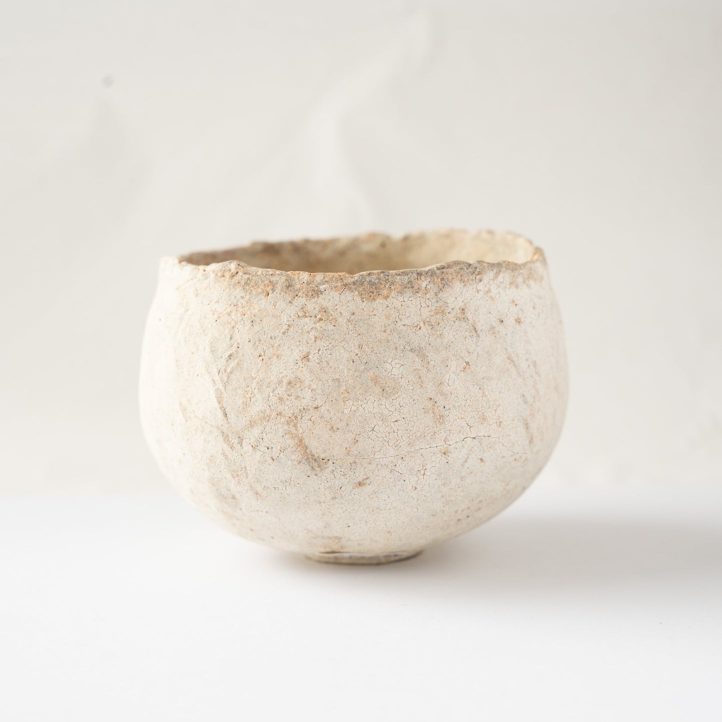 Alternate side profile of Wataru Myosyu's Bao small ceramic bowl, displaying subtle earthen blushes beneath the white slip.