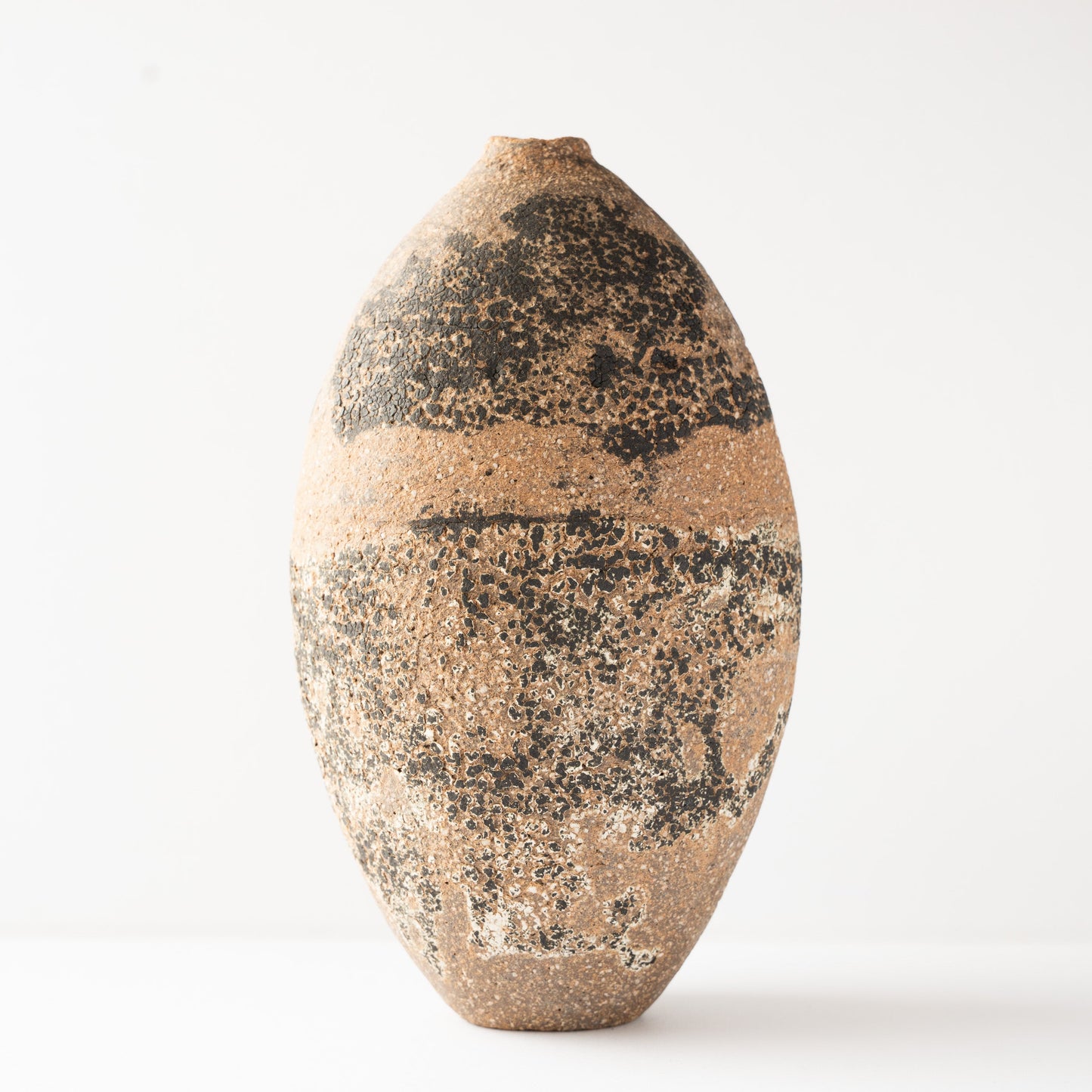 Full front view of Wataru Myosyu's Genkoku vase, featuring the wide band of dark encrustation and earthy clay tones.