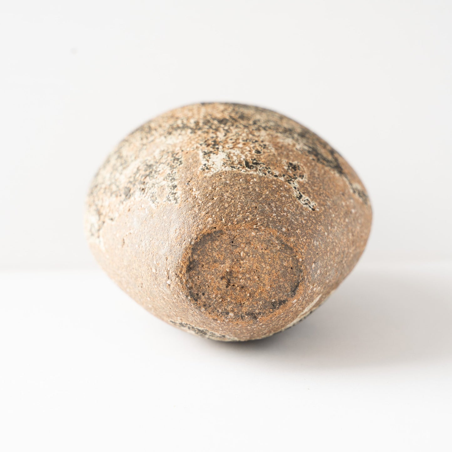 Bottom view of the unglazed base of Wataru Myoshu’s Genkoku flower vase, displaying the warm terracotta clay texture.