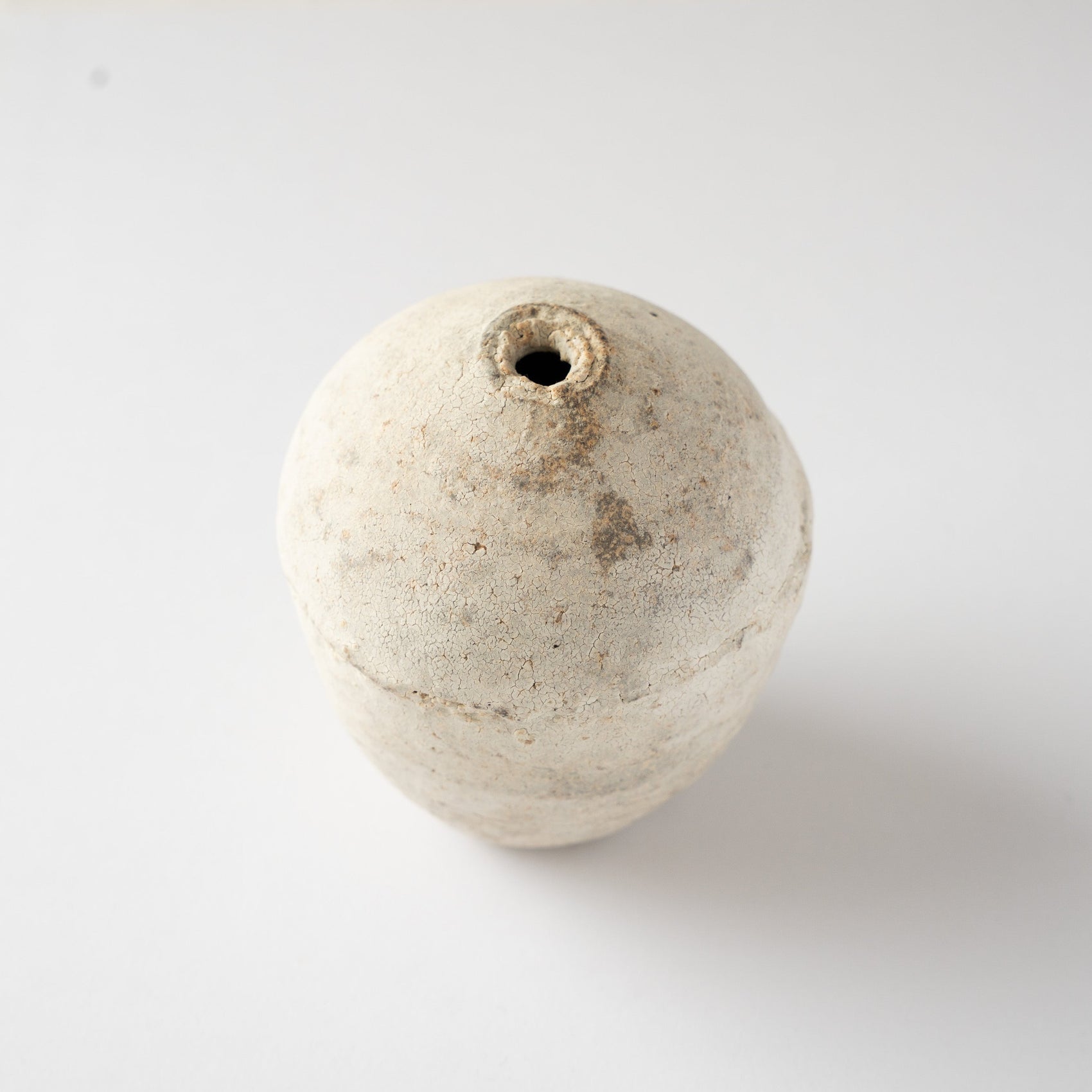 High-angle view looking down at the narrow rim and rounded shoulder of Wataru Myosyu’s Hakkoku Ko white ceramic vase.