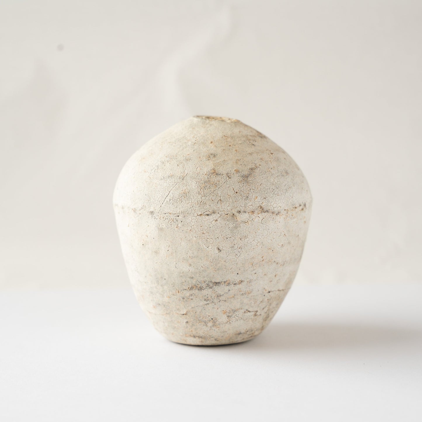 Studio profile of Wataru Myosyu's Hakkoku Ko ceramic flower vessel, showcasing soft ochre and grey tonal shifts across the white slip.