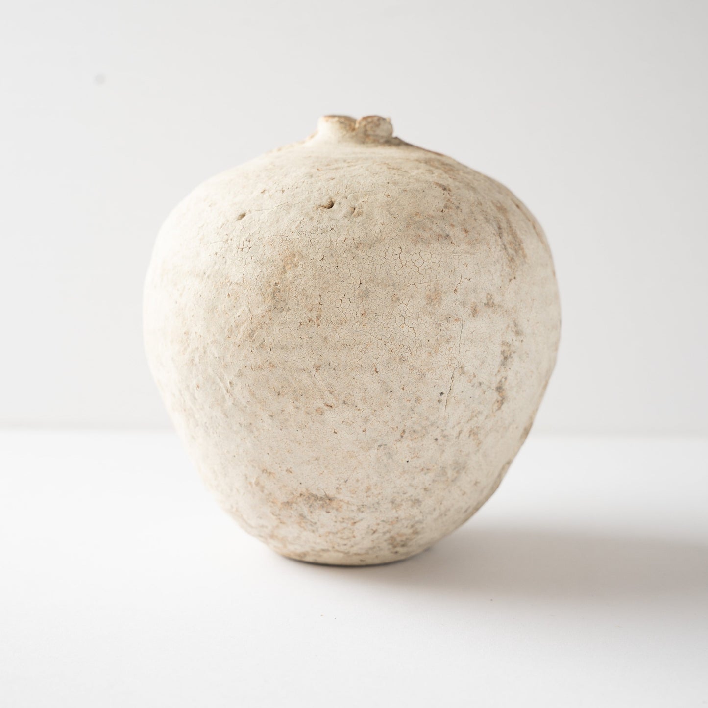 Smooth side facade of Wataru Myosyu’s Hakkoku Tada white ceramic vase, detailing the subtle iron specks and crackle glaze.