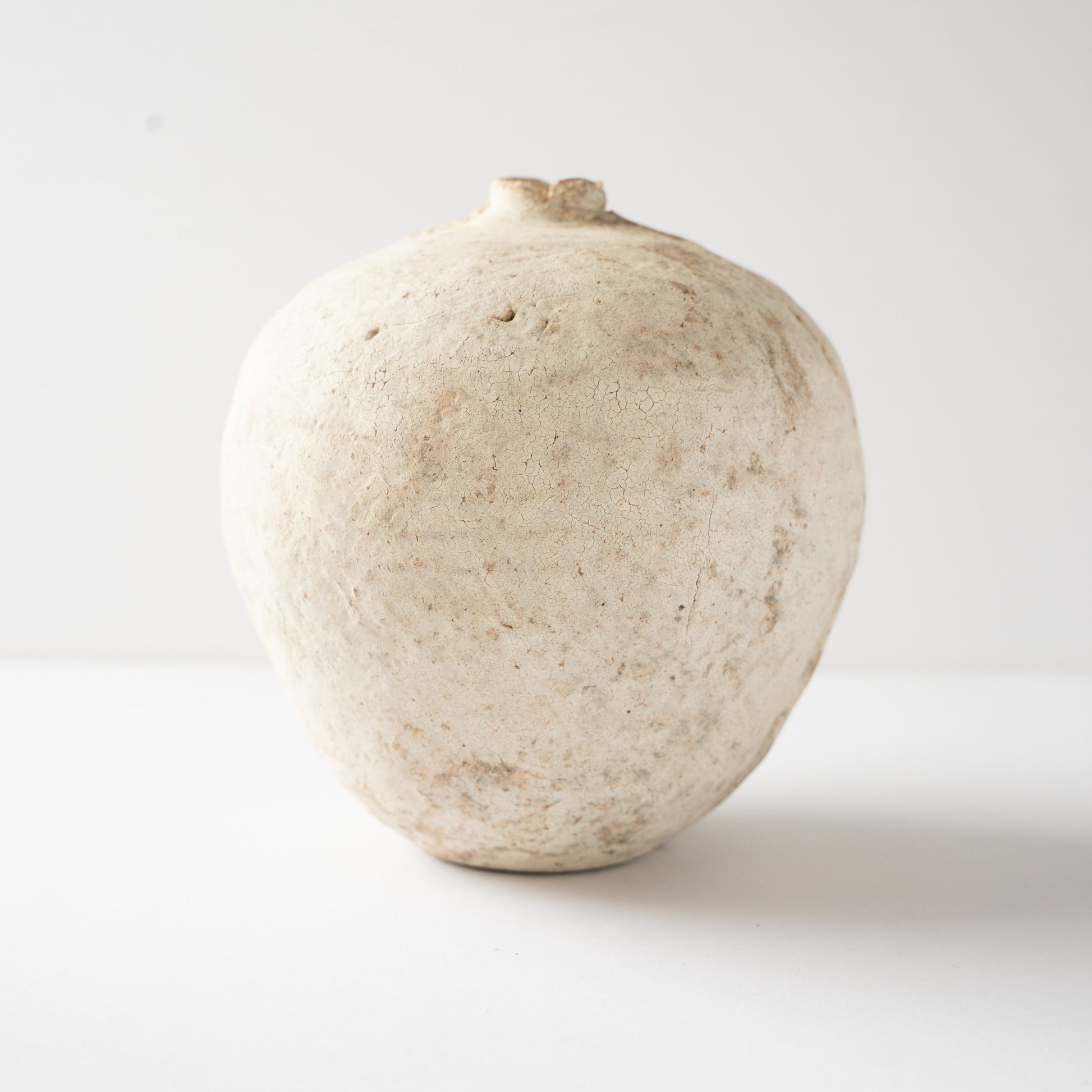 Smooth side facade of Wataru Myosyu’s Hakkoku Tada white ceramic vase, detailing the subtle iron specks and crackle glaze.