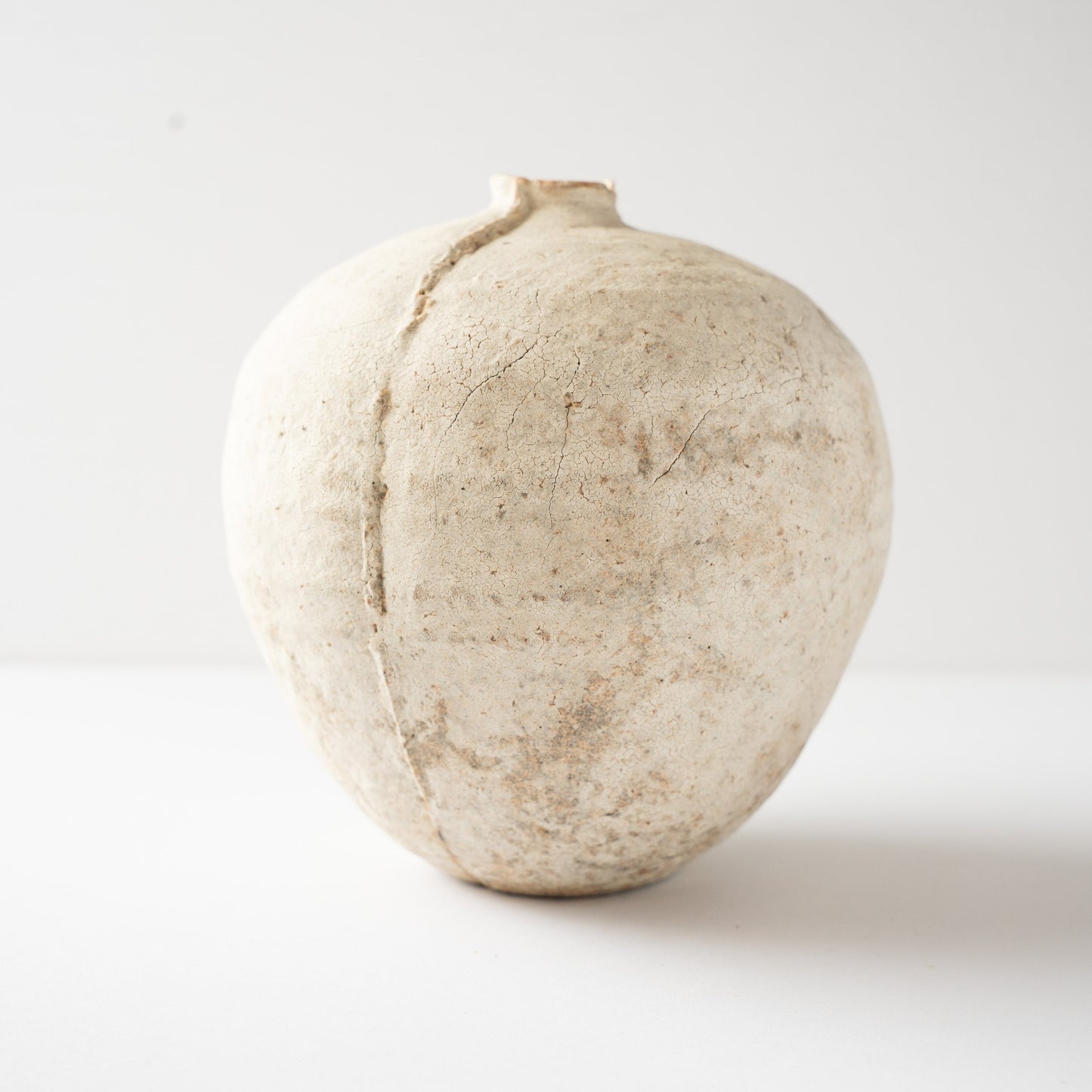 Profile view of the Hakkoku Tada HANAIRE vase by Wataru Myosyu, showing the prominent vertical seam line running down the chalky body.
