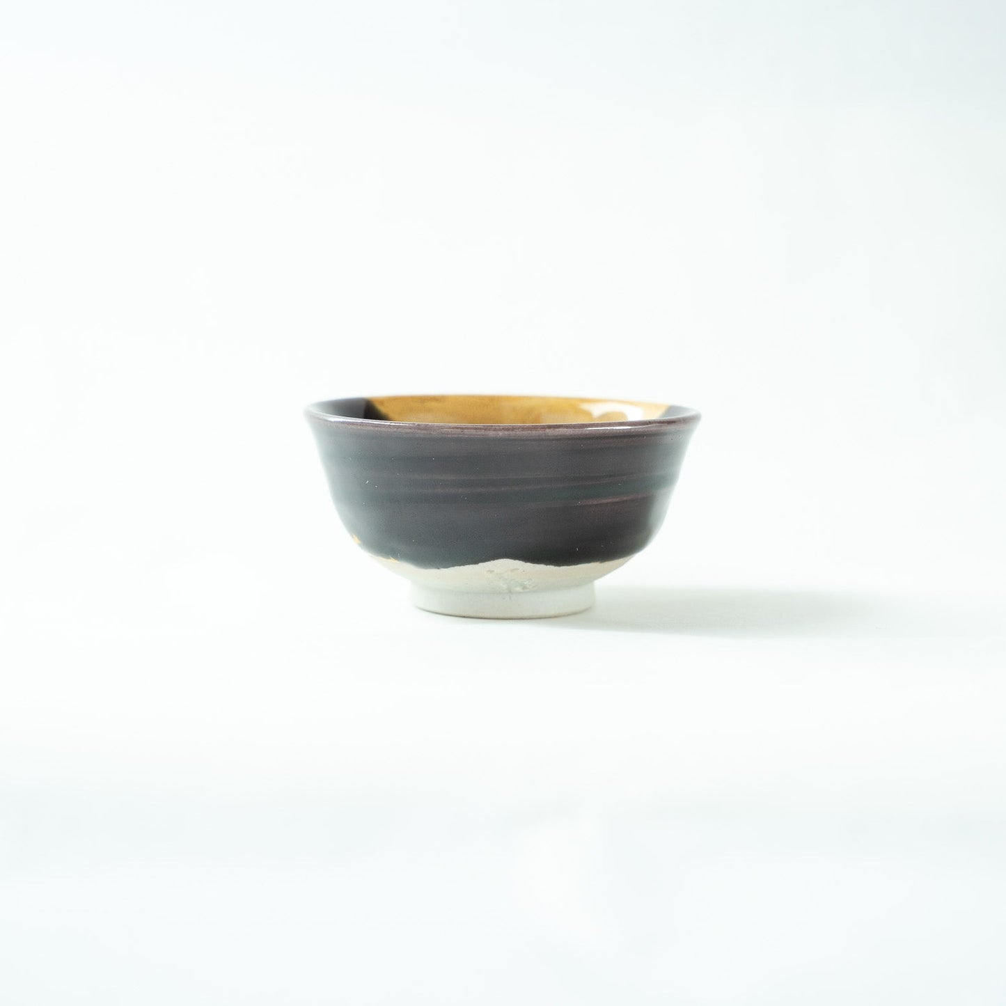 View of the predominantly dark glazed side of the GUINOMI, displaying a serene profile and elegant silhouette.