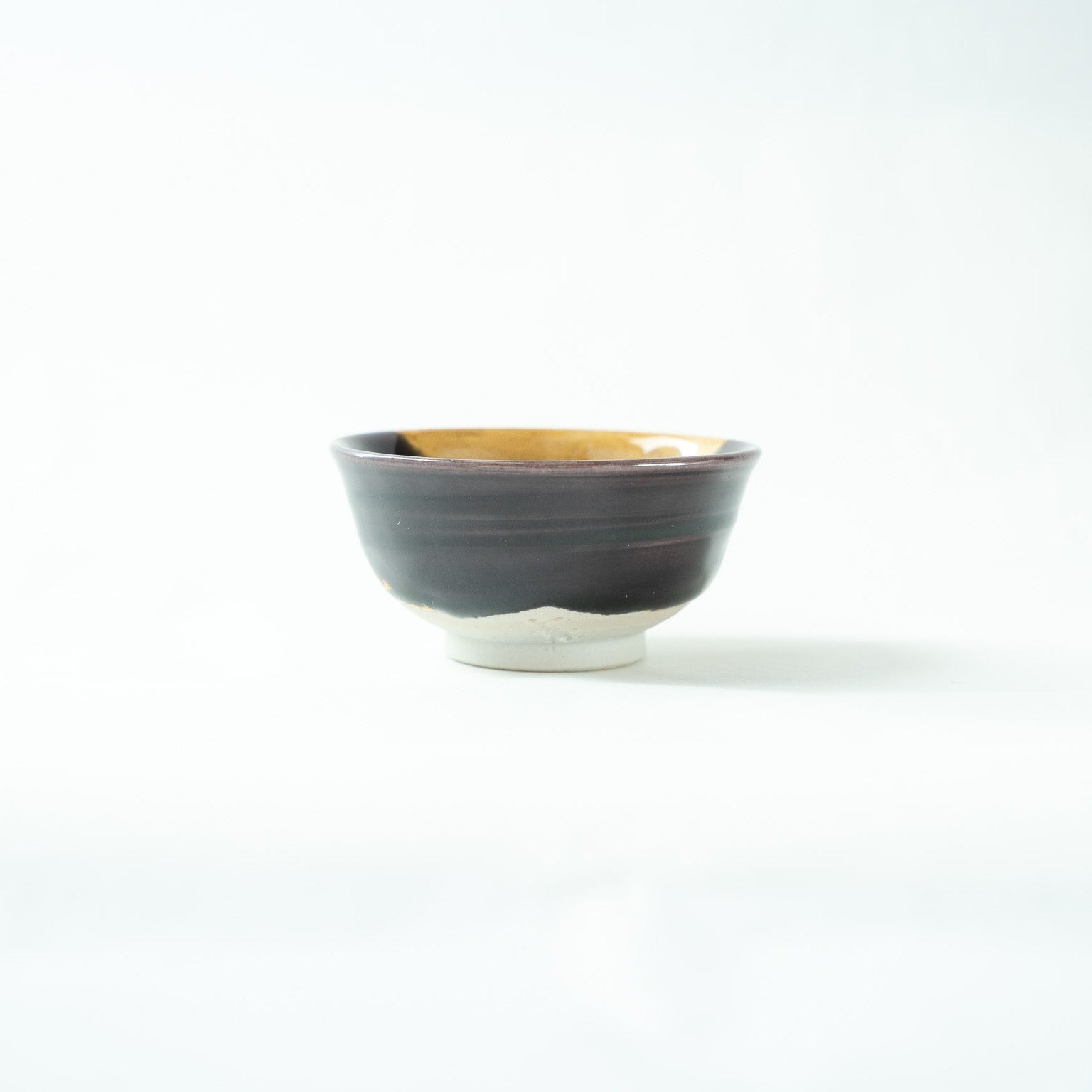 View of the predominantly dark glazed side of the GUINOMI, displaying a serene profile and elegant silhouette.