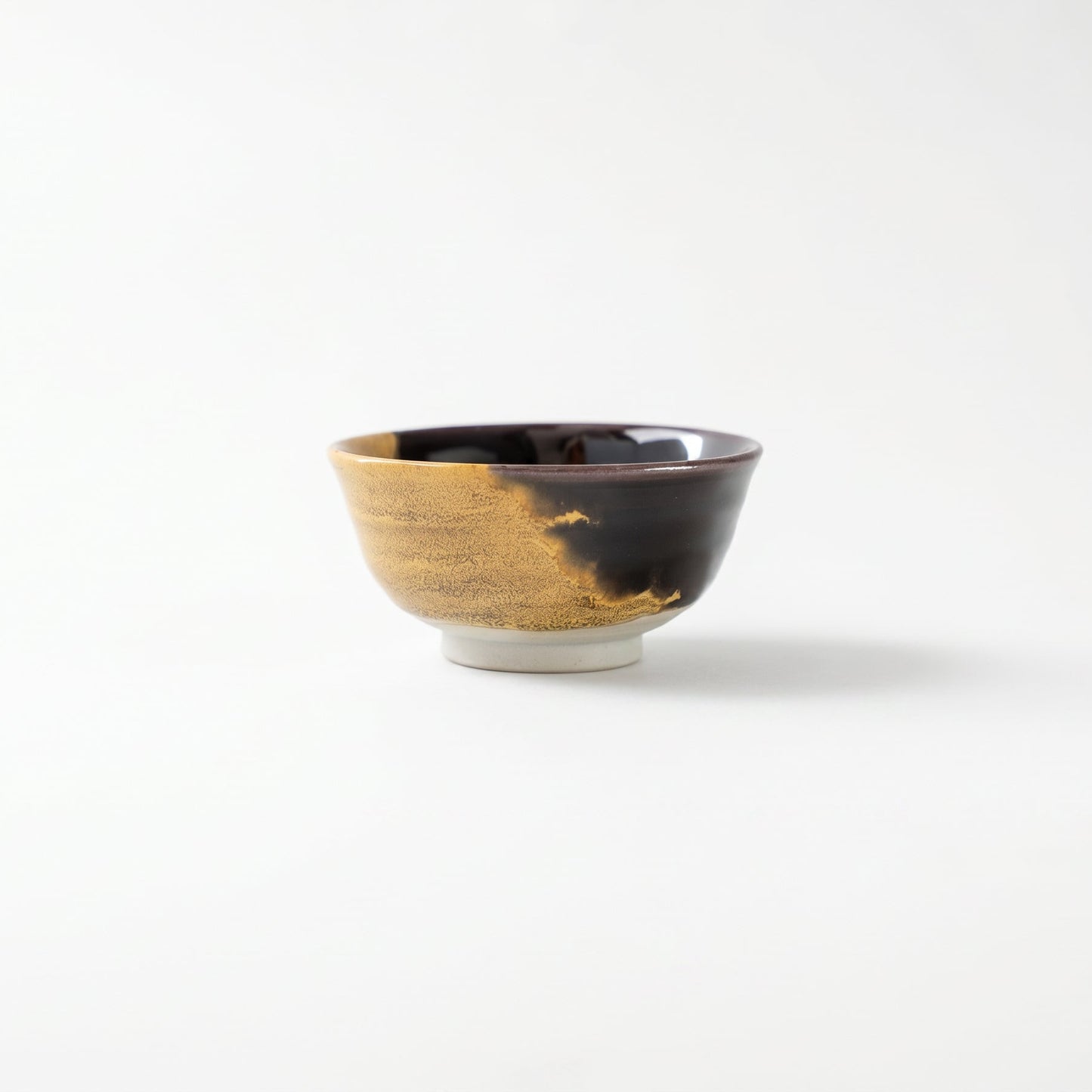 Front view of the Kutani GUINOMI by Tokuda Yasokichi III, showcasing the bold asymmetrical boundary where black and gold glazes meet.