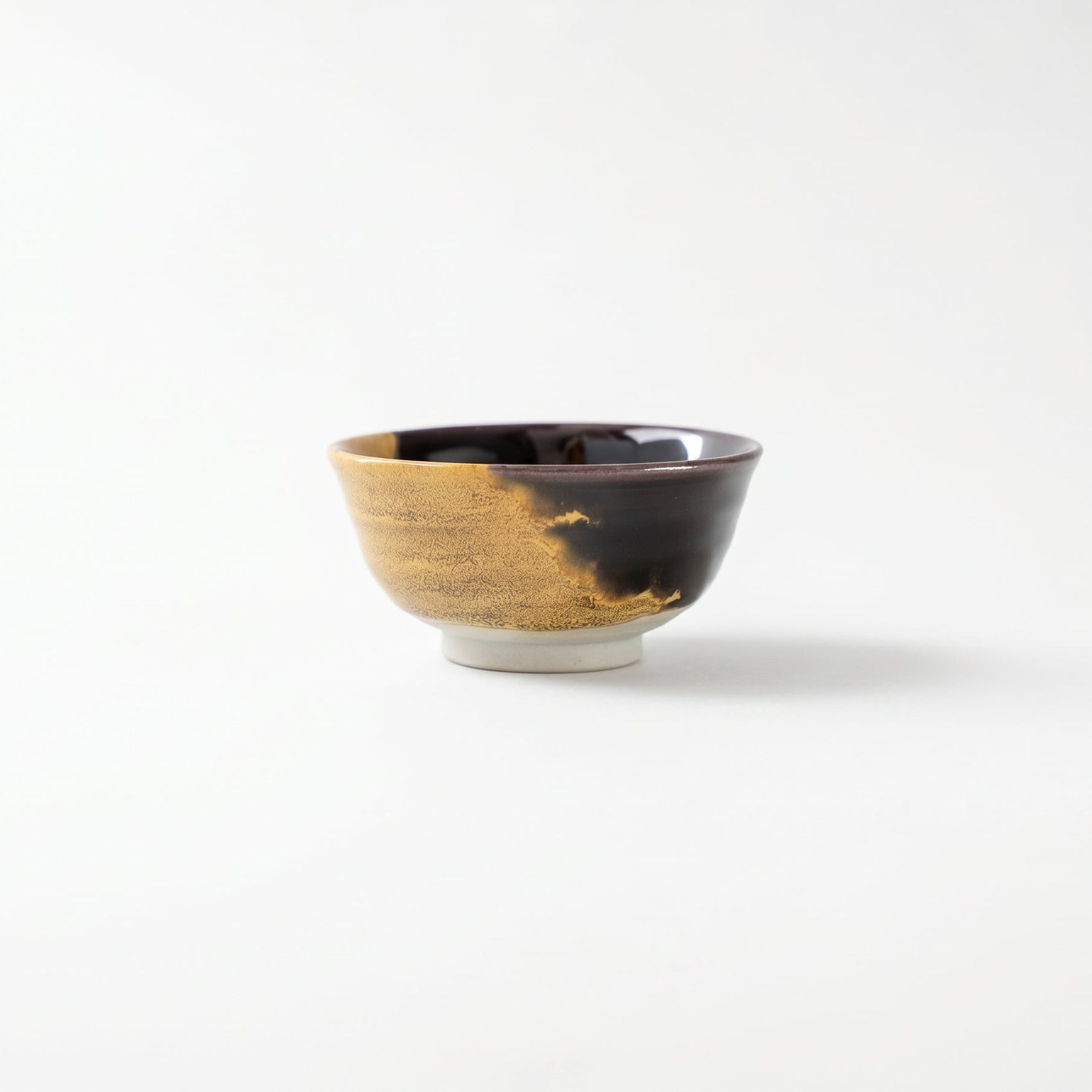 Front view of the Kutani GUINOMI by Tokuda Yasokichi III, showcasing the bold asymmetrical boundary where black and gold glazes meet.
