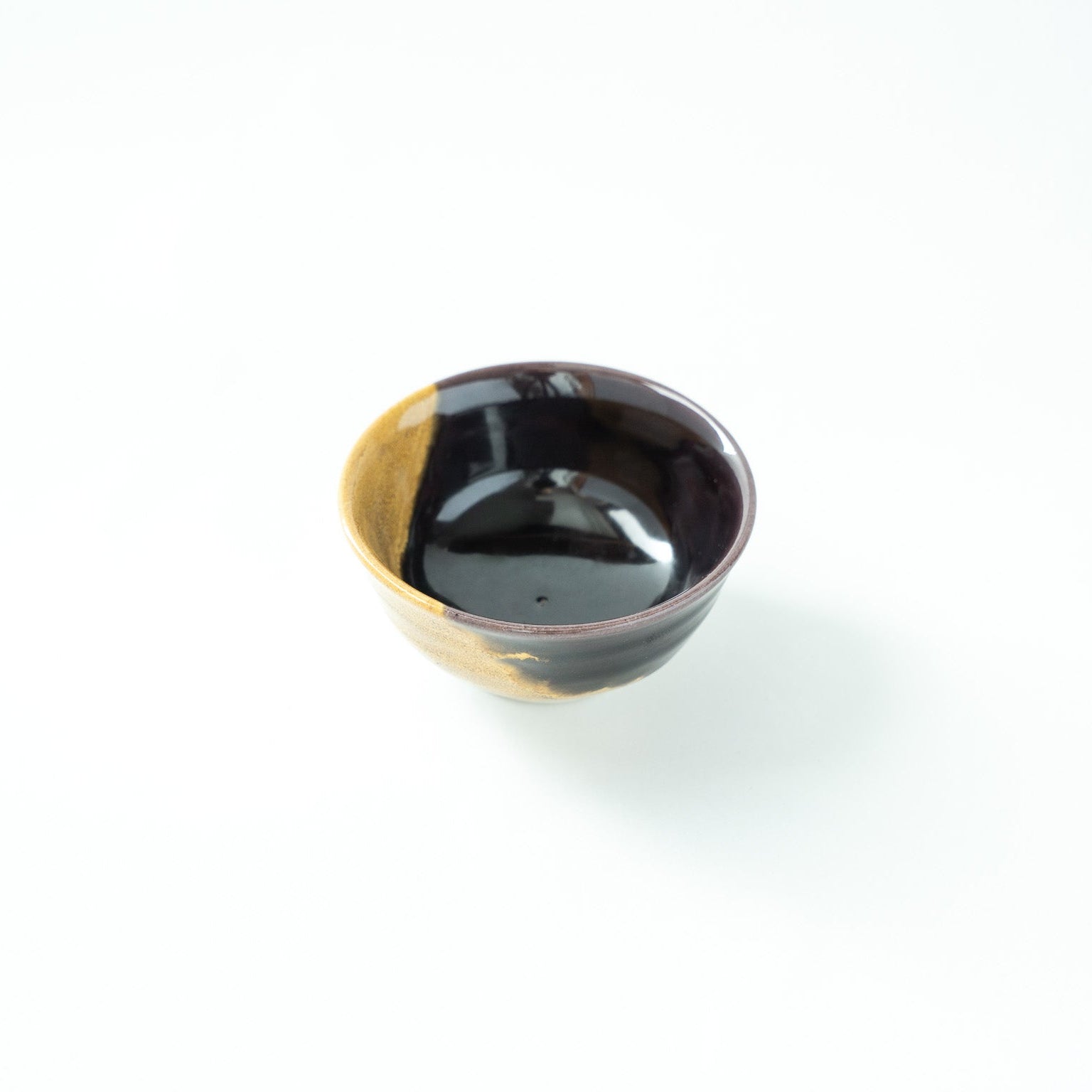Top-down angled view of the Kutani GUINOMI, showing the deep black interior contrasted with a flash of gold on the rim.