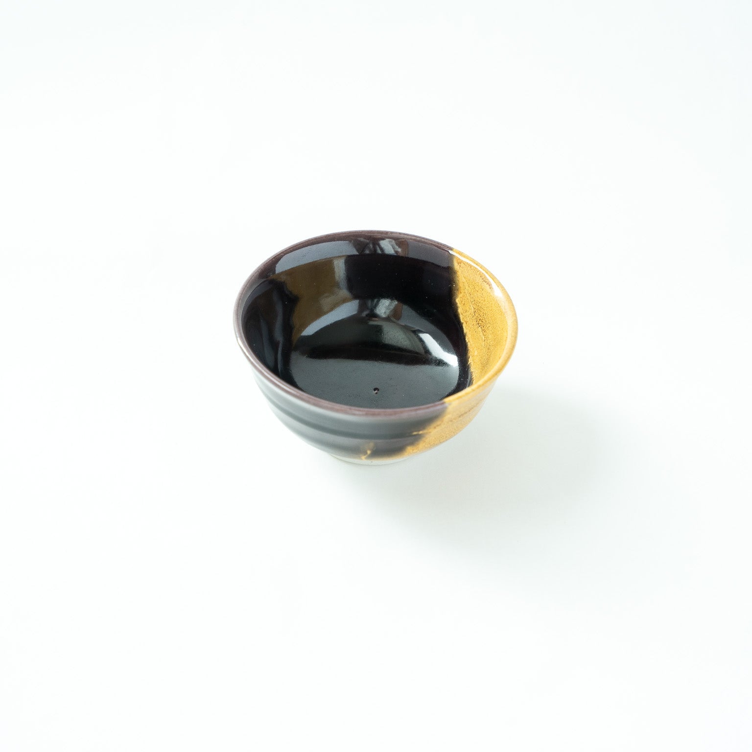 Top angled view revealing the glossy black interior of the vessel and the precise glaze transition on the right.