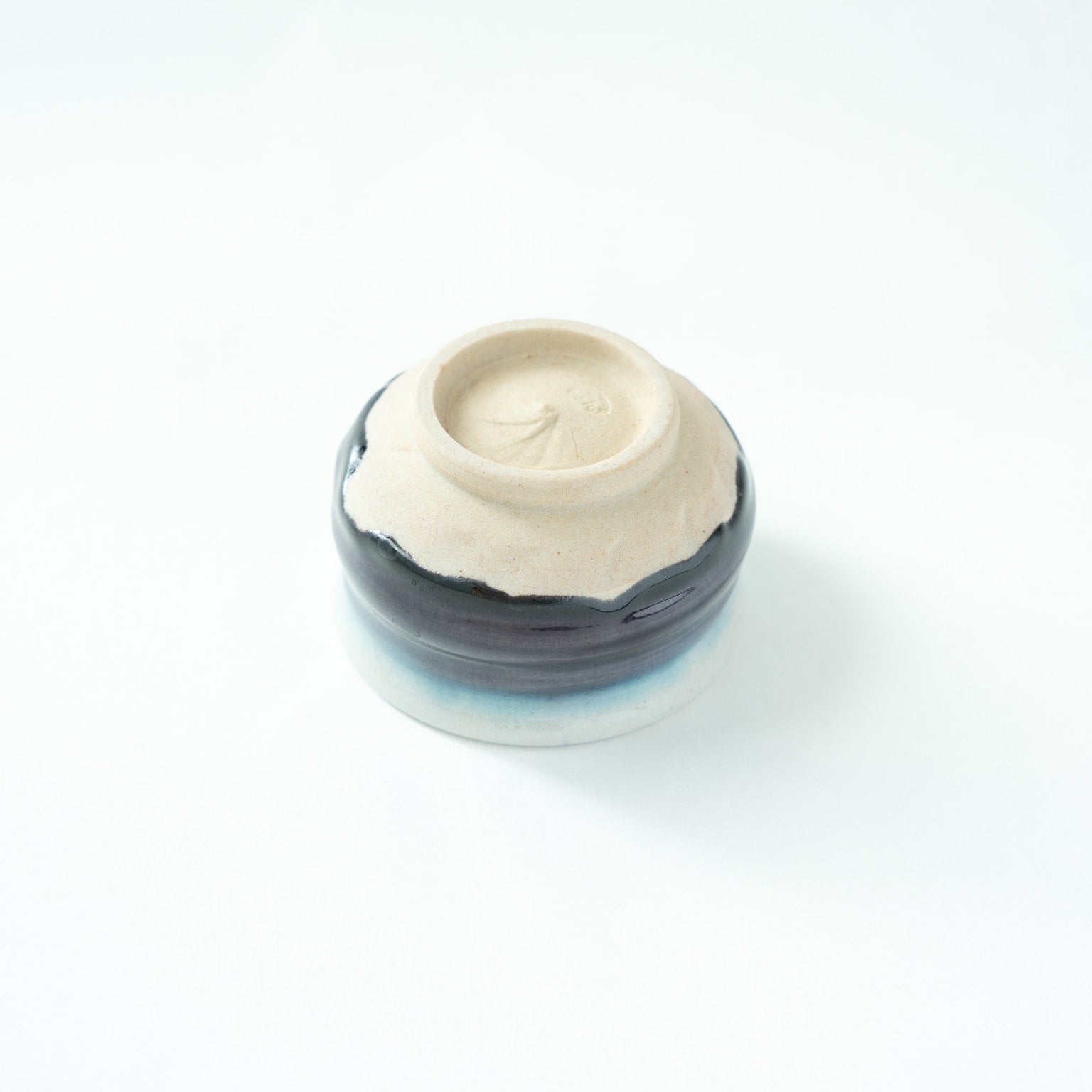 Detailed view of the clean white ceramic foot (kodai), emphasizing the refined materiality and signature trace of contemporary Kutani ware.