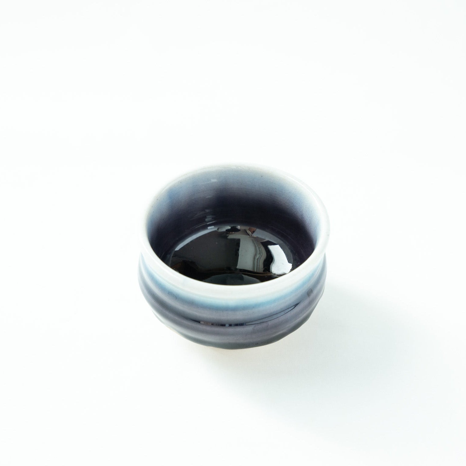 Top-down angled view looking into the deep, reflective indigo interior of the GUINOMI by Tokuda Yasokichi III.