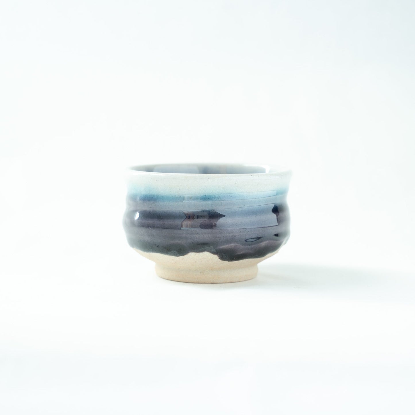 A detailed view of the vessel's exterior, highlighting the horizontal bands of shifting blue and indigo glazes.