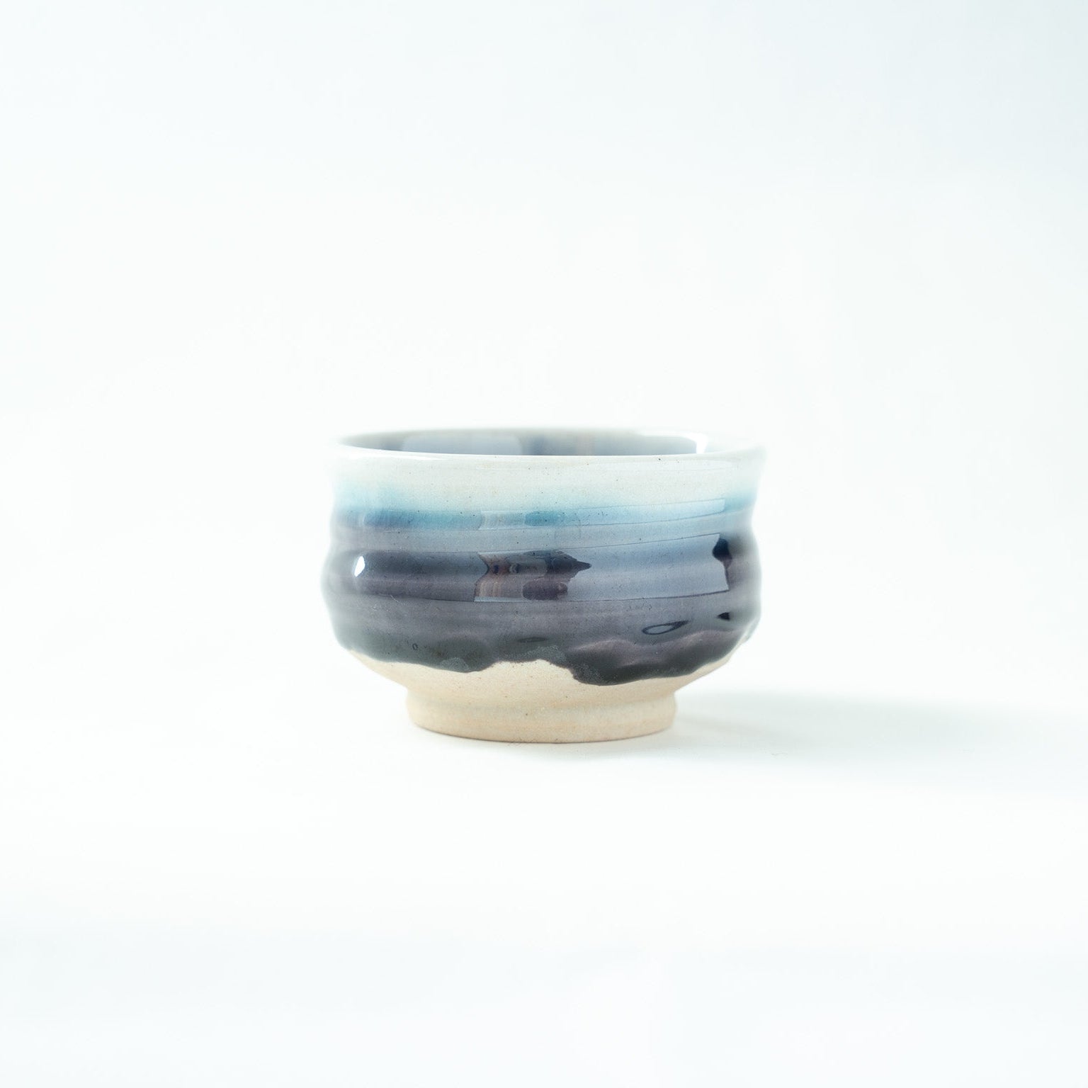 A detailed view of the vessel's exterior, highlighting the horizontal bands of shifting blue and indigo glazes.