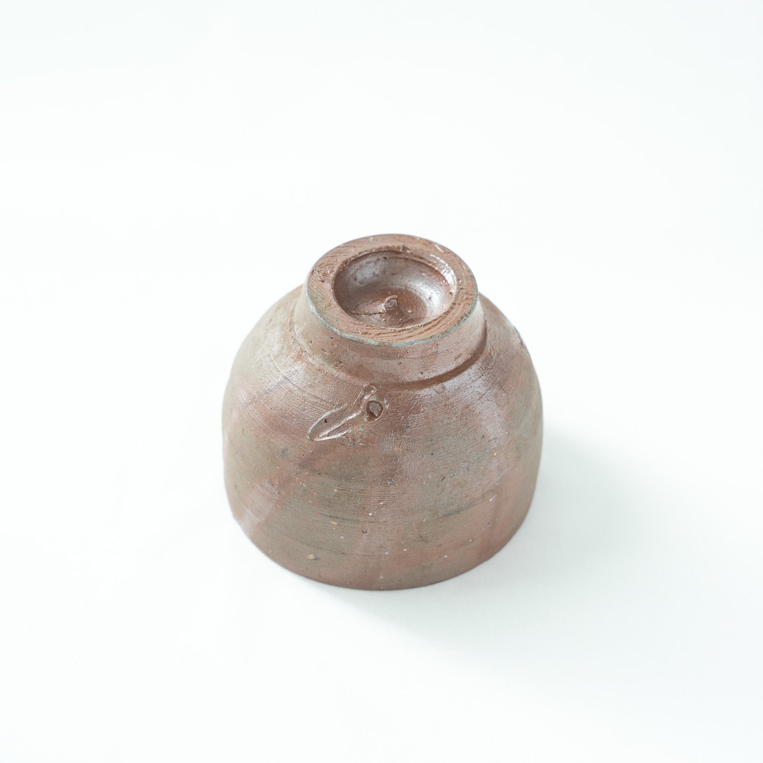 Inverted view of the vessel, showcasing the finely turned foot and the artist's incised potter's mark on the base.