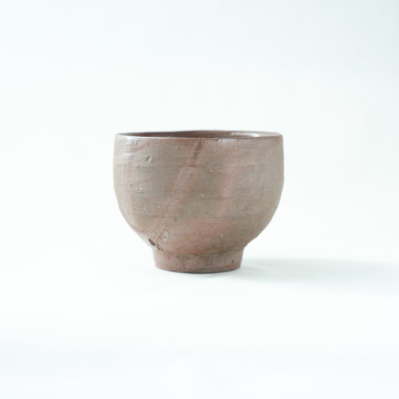 Side view of the Bizen sake cup, revealing soft reddish flame marks produced by natural kiln transformation.
