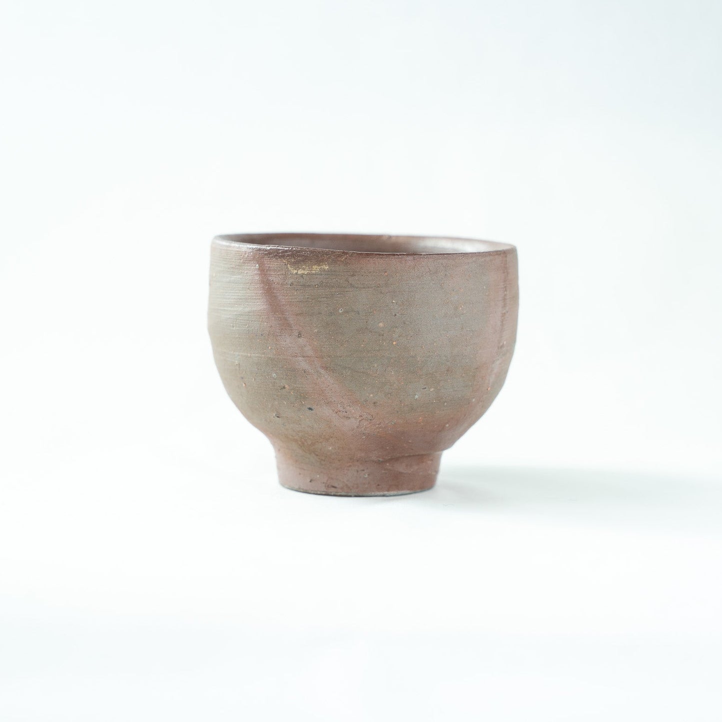 Another side view of the vessel, capturing the deep, warm earth tones and subtle variations of the fired clay.