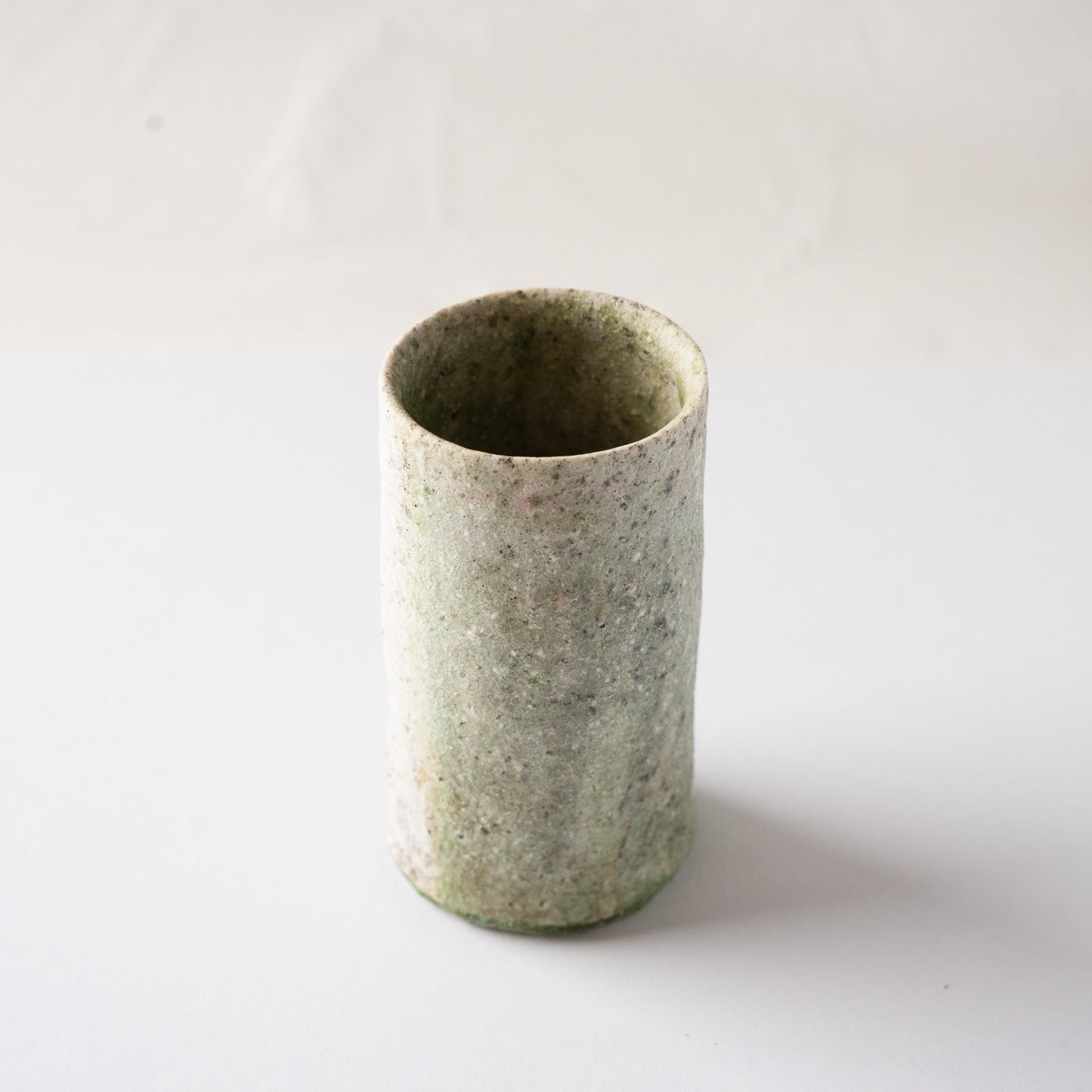High-angle view looking down at the irregular rim and spacious interior of the natural ash glaze cylindrical YUNOMI by Yui Tsujimura.