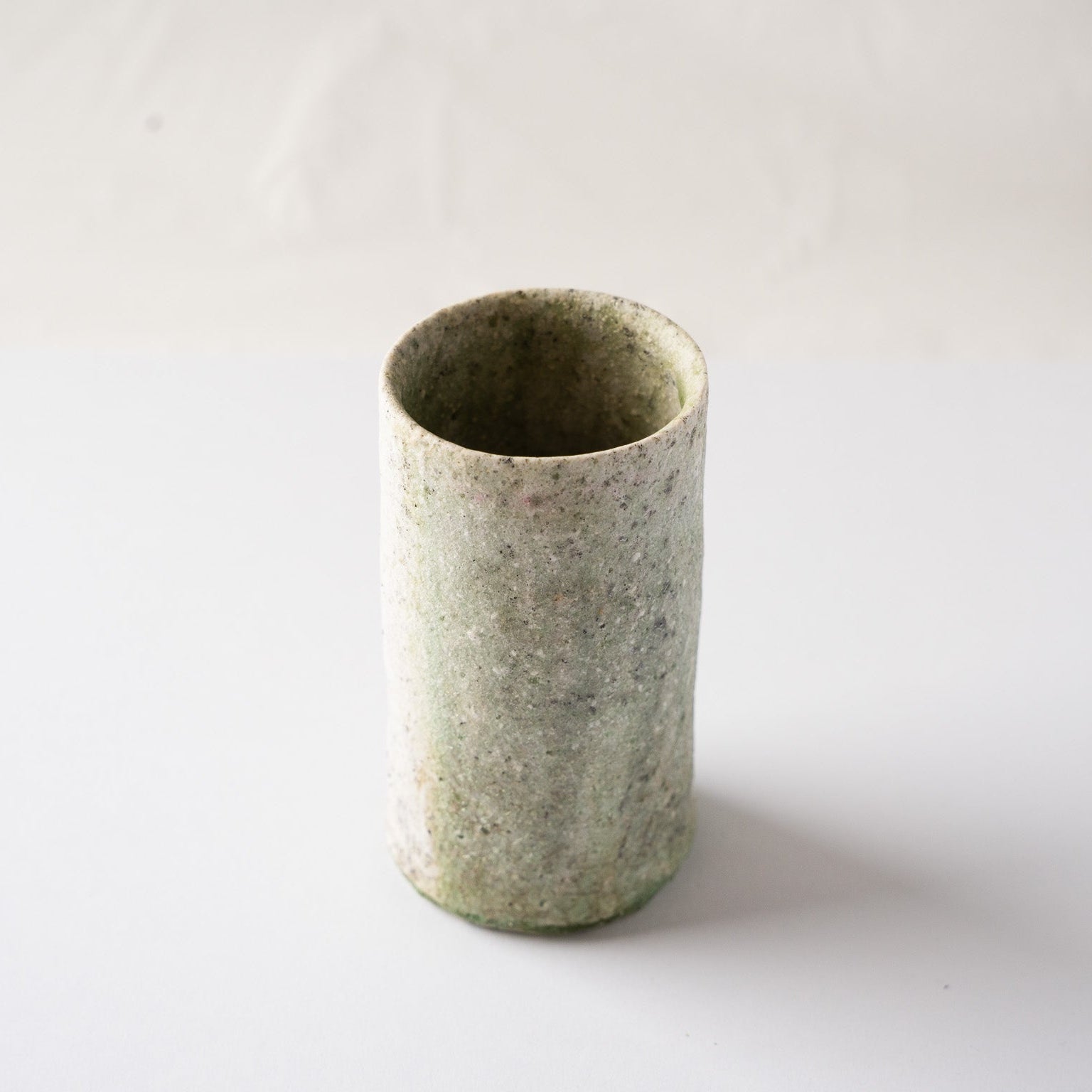 High-angle view looking down at the irregular rim and spacious interior of the natural ash glaze cylindrical YUNOMI by Yui Tsujimura.