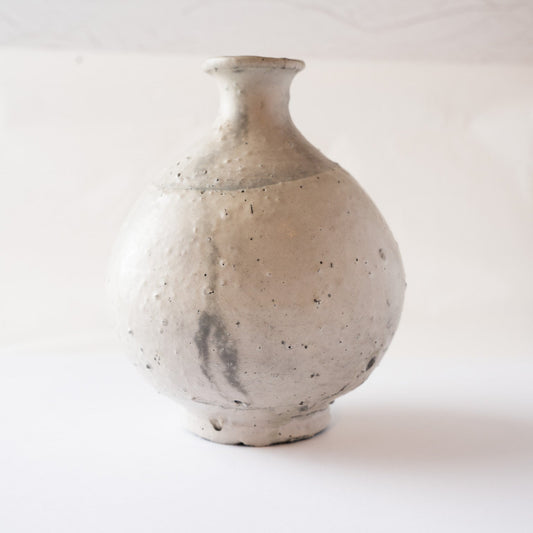 Profile view of the natural ash glaze TOKKURI by Yui Tsujimura, displaying a dark charcoal kiln marking across the lower rounded surface.