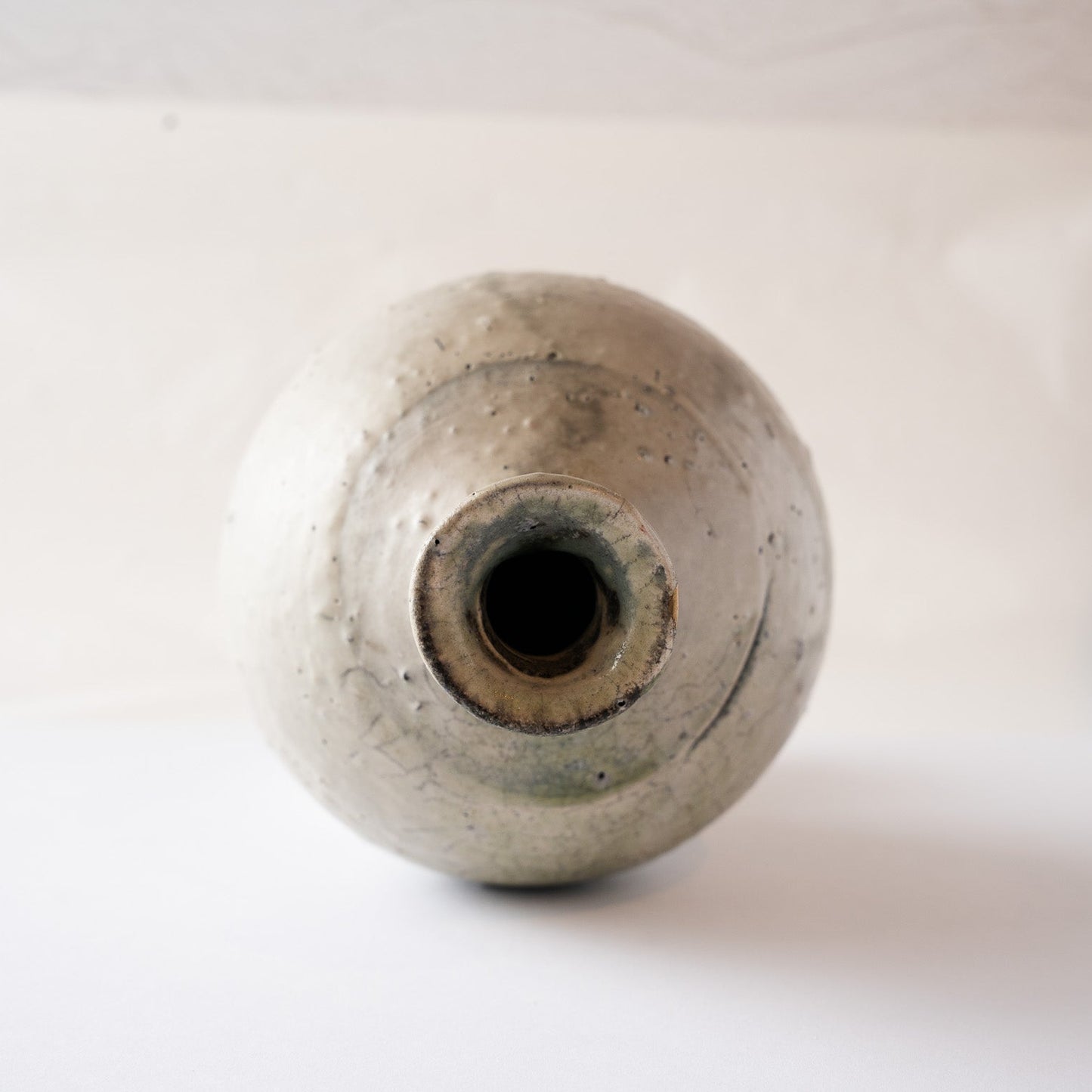 Overhead view looking down into the narrow neck of the natural ash glaze TOKKURI sake flask by Yui Tsujimura.