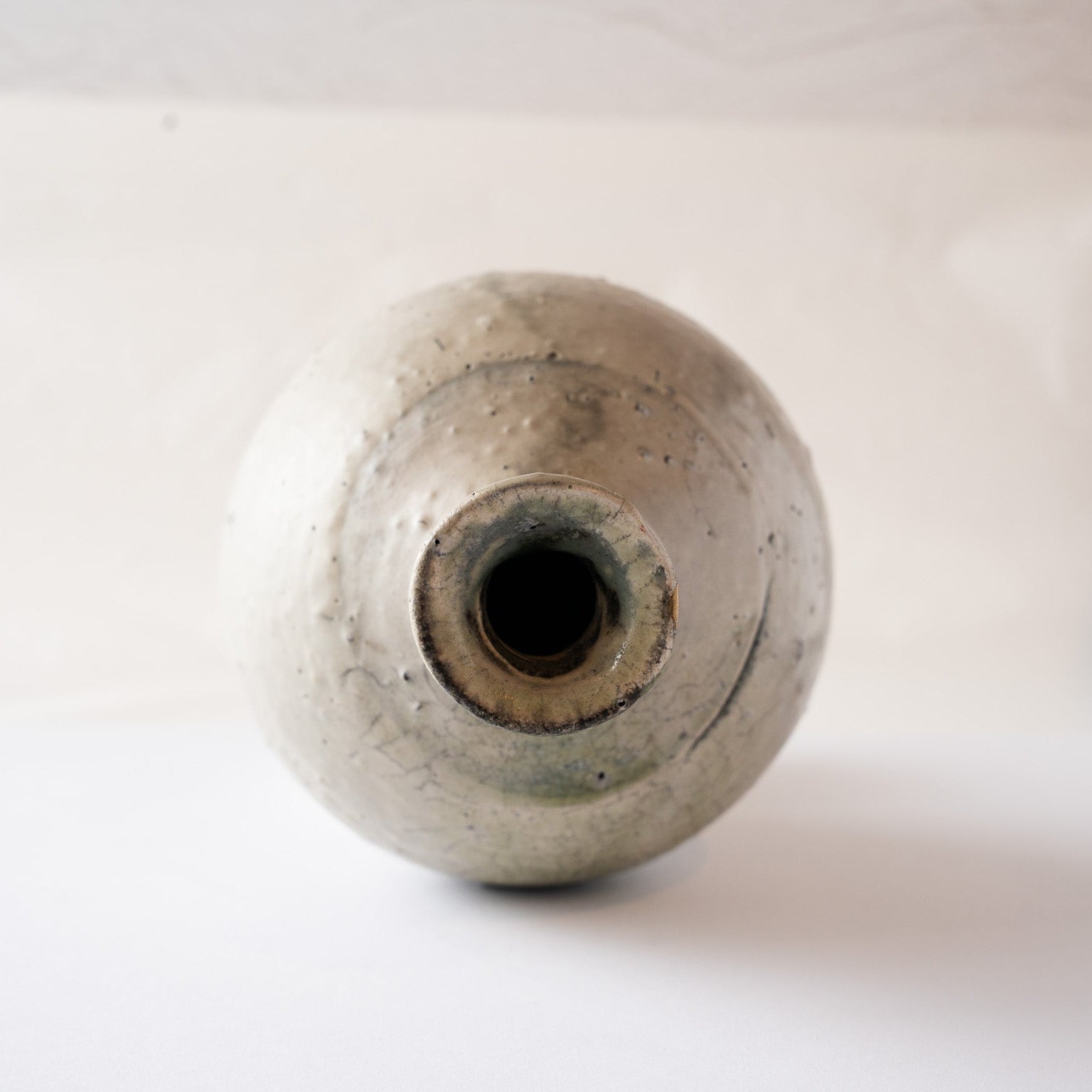 Overhead view looking down into the narrow neck of the natural ash glaze TOKKURI sake flask by Yui Tsujimura.